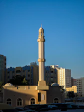 A tall mosque minaret stands in a city.
