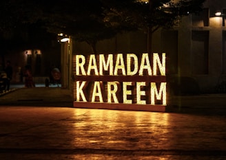 Ramadan kareem is illuminated at night.