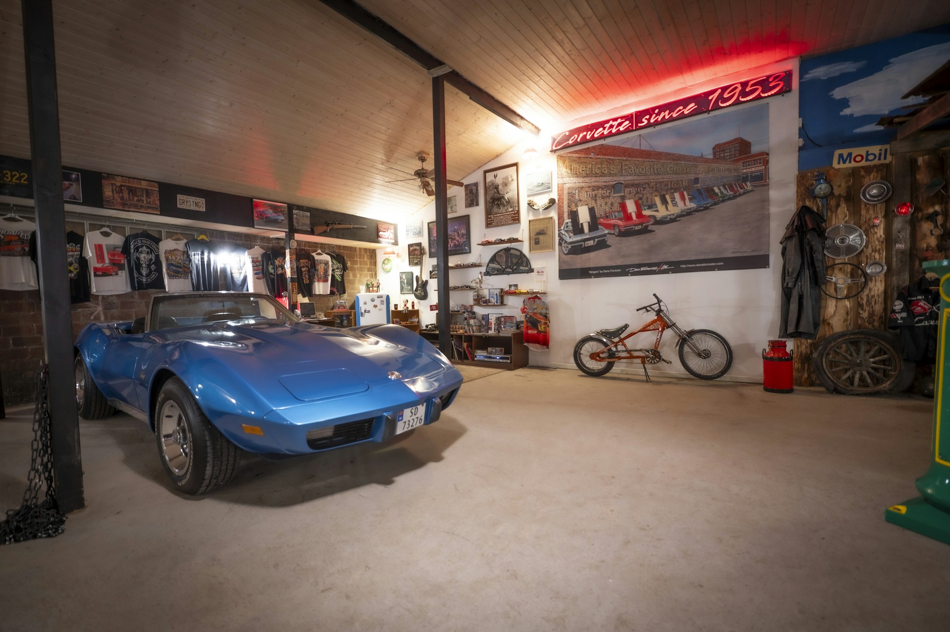A classic blue corvette is in a garage.