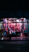 A butcher stands in front of his shop.
