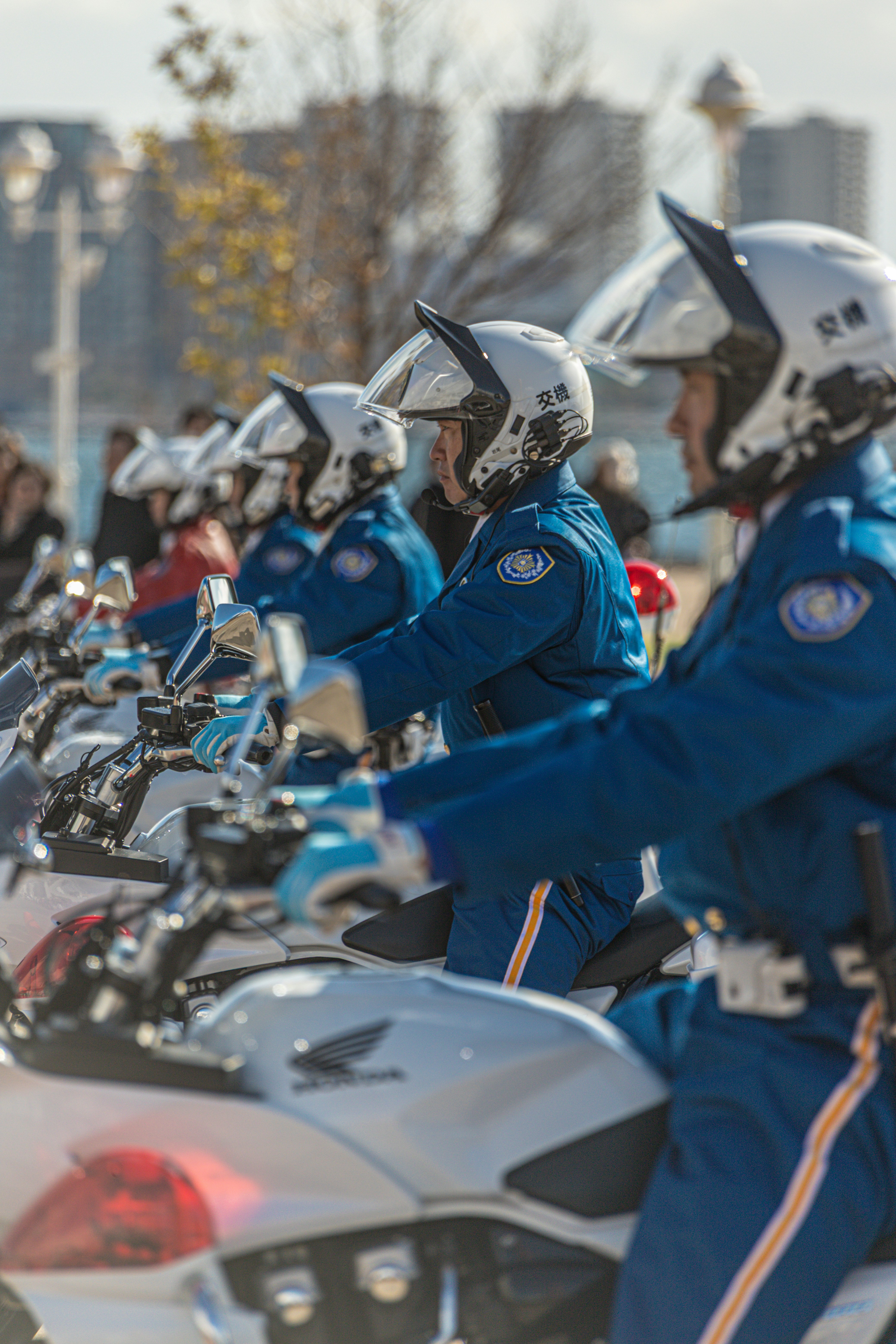 Japanese police officers on motorcycles line up.