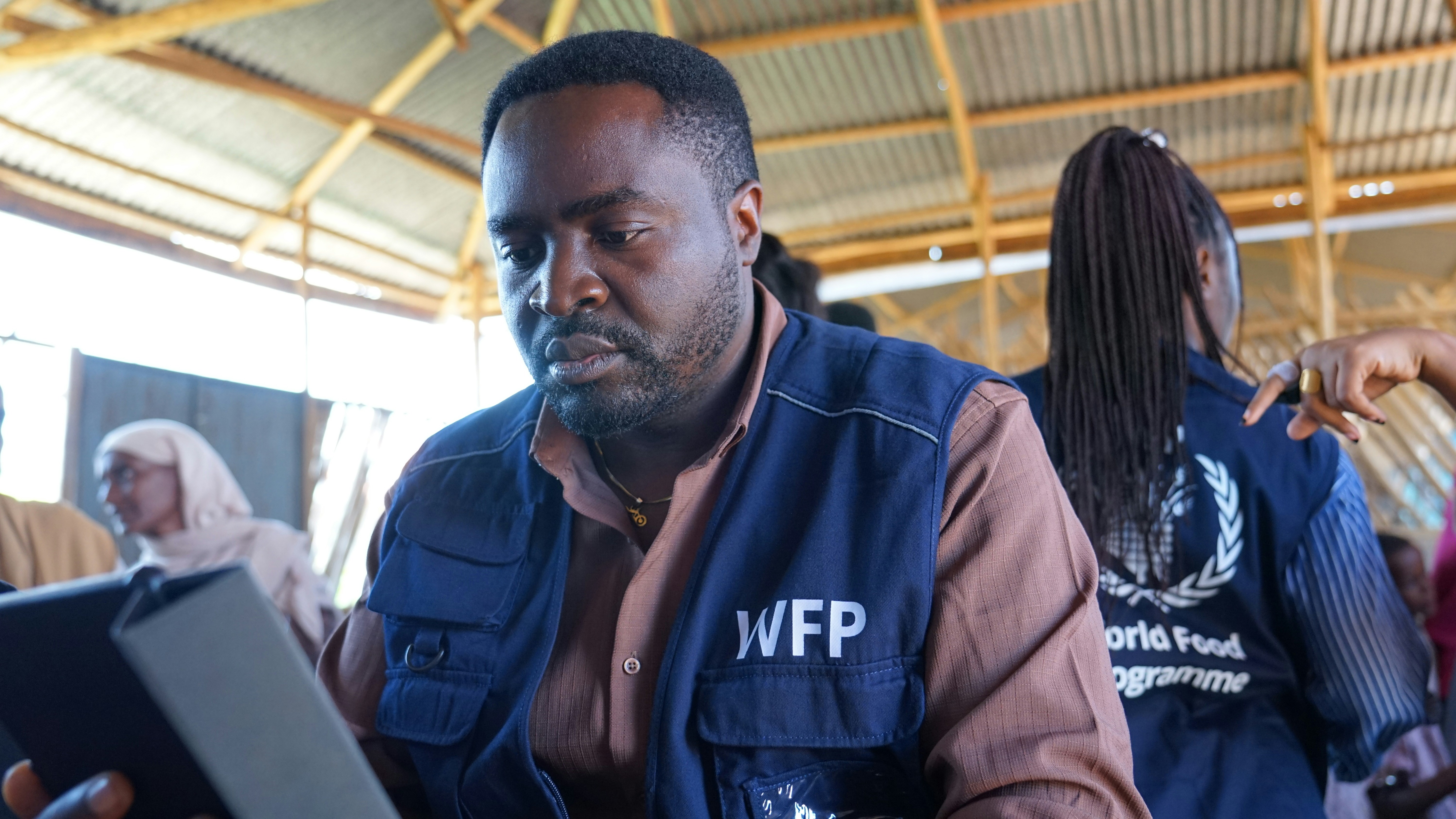 A wfp worker uses a tablet in a field.