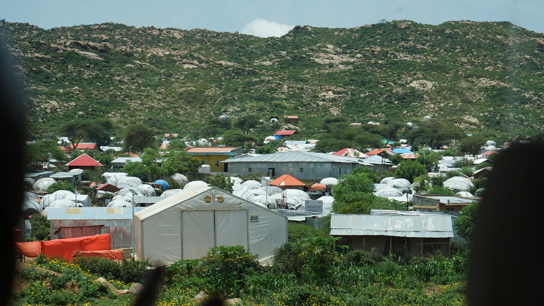 A community settlement in Kenya nestled in a green landscape