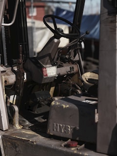 Forklift interior with steering wheel is visible.