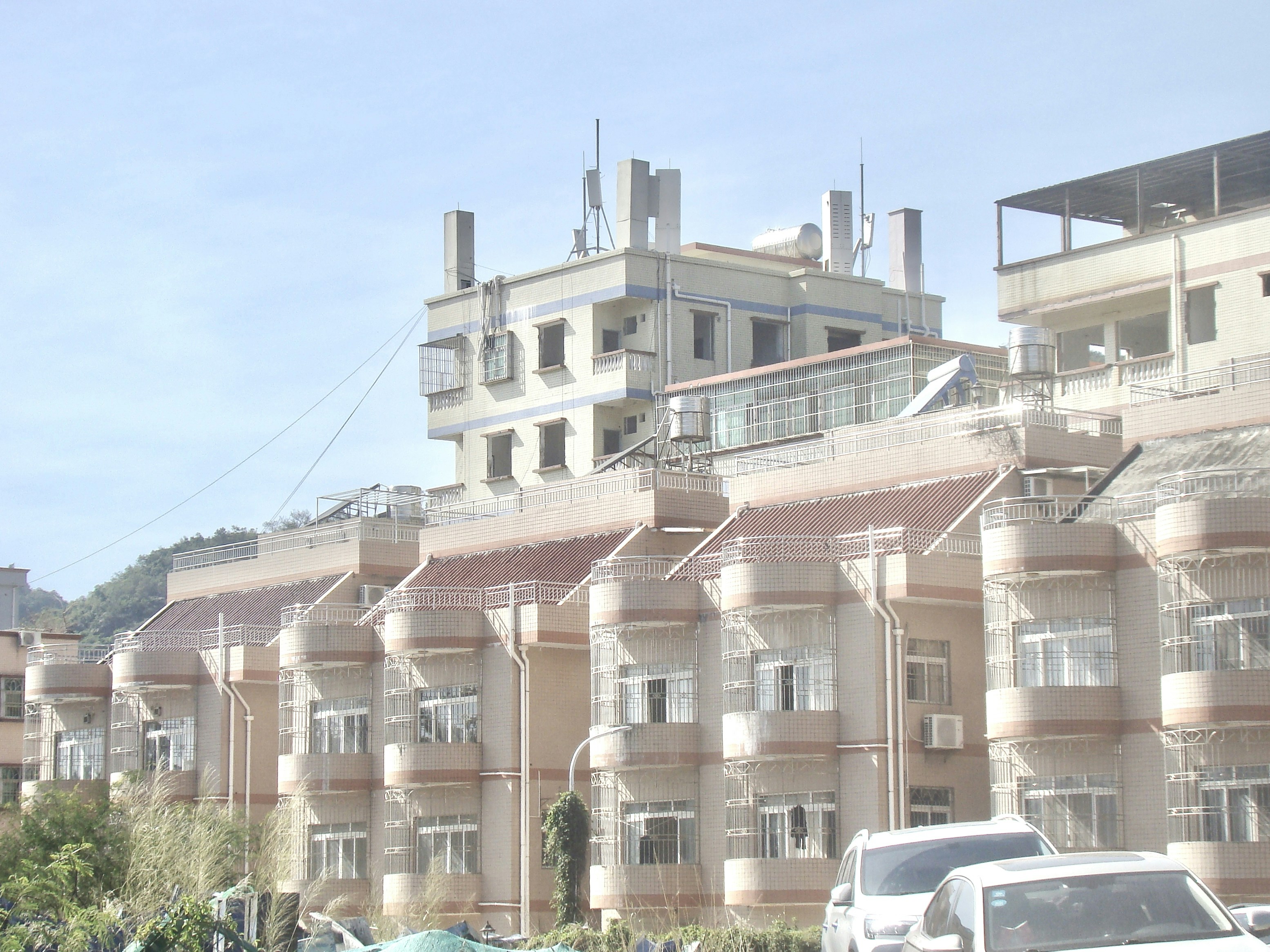 A row of buildings is shown on a hill.