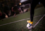 A soccer player stands on the ball.