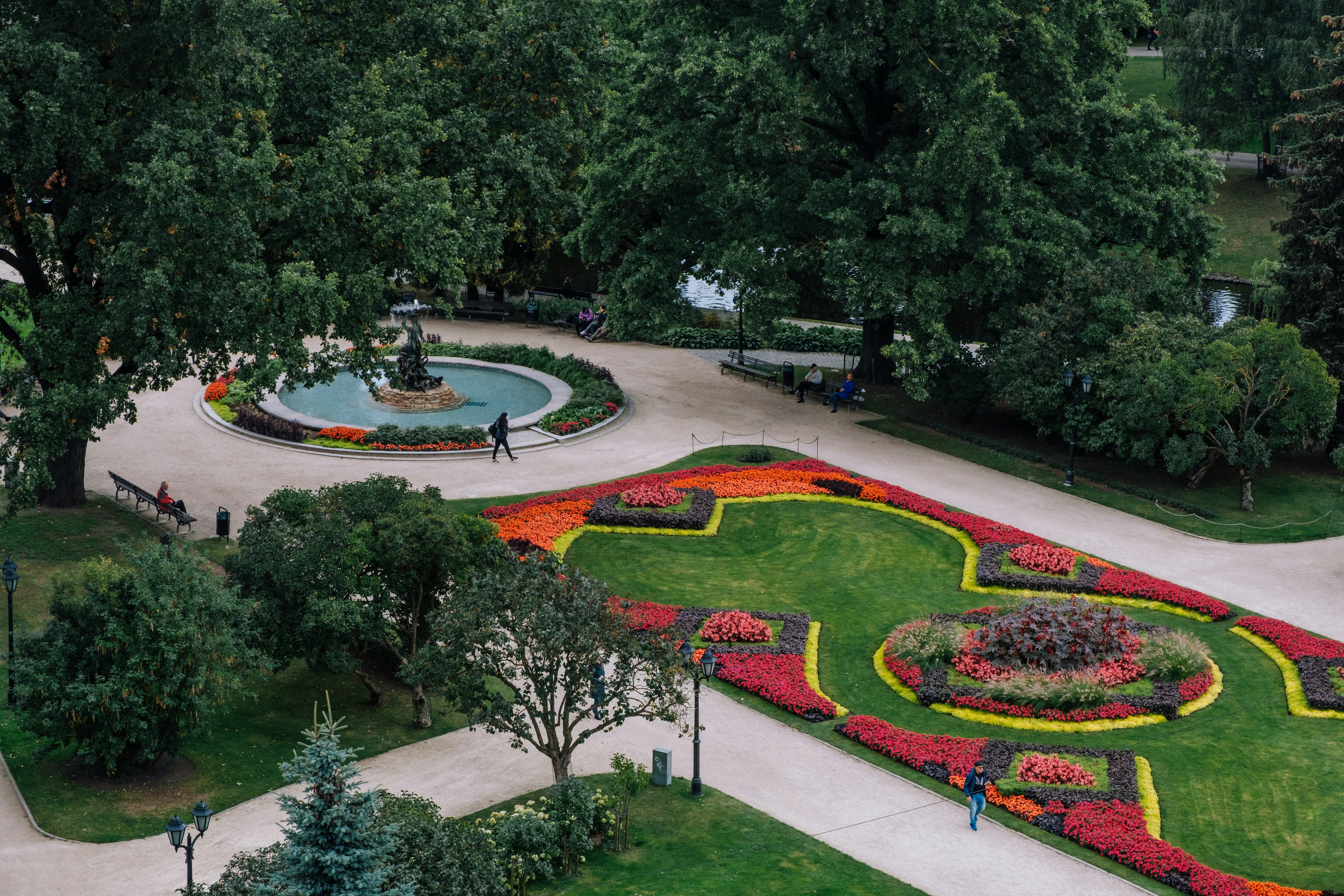A lush park has a colorful floral display.