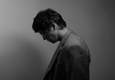 A person in a jacket looking down.