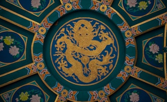 A golden dragon is centered in an ornate ceiling.