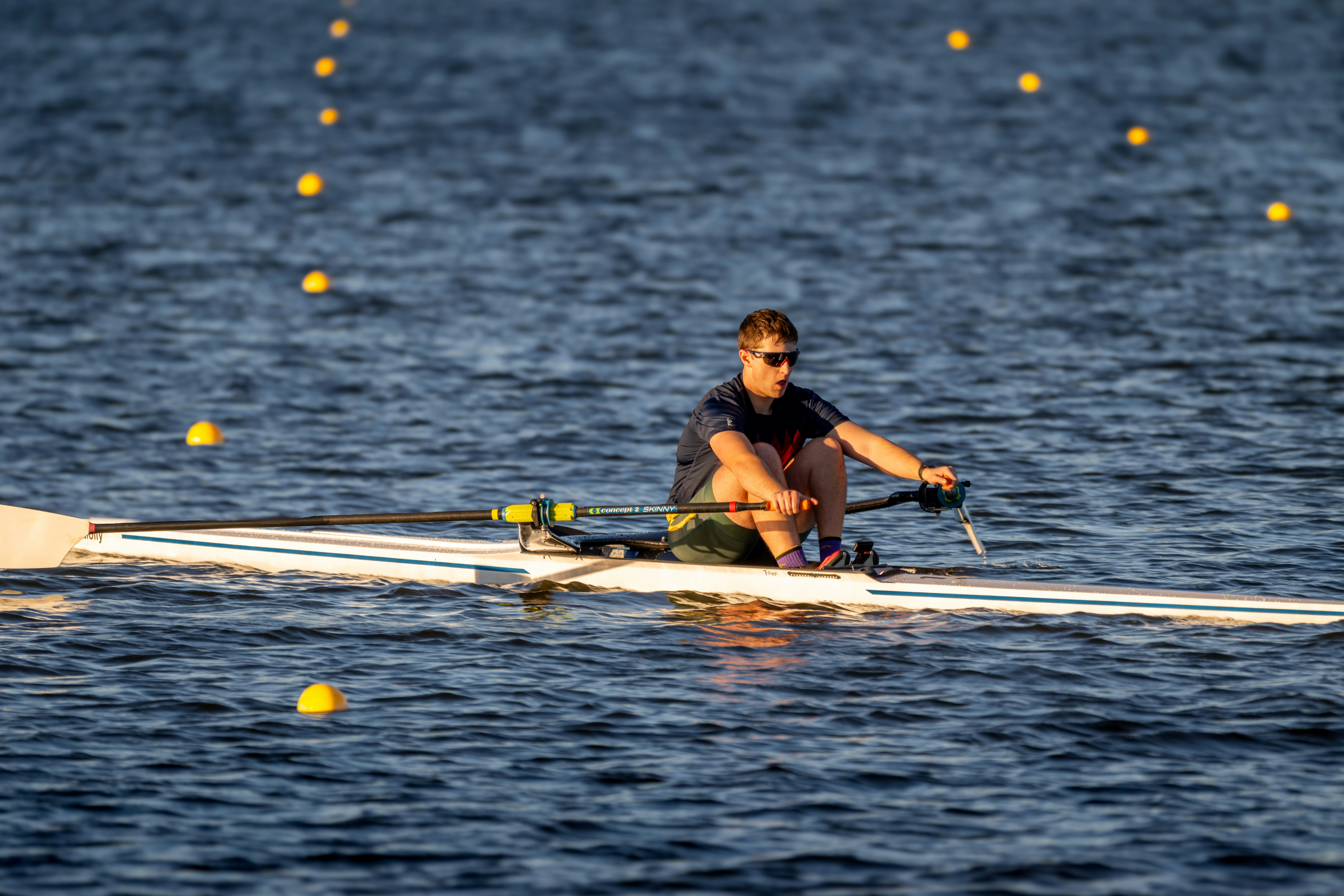 A rower is on the water rowing.