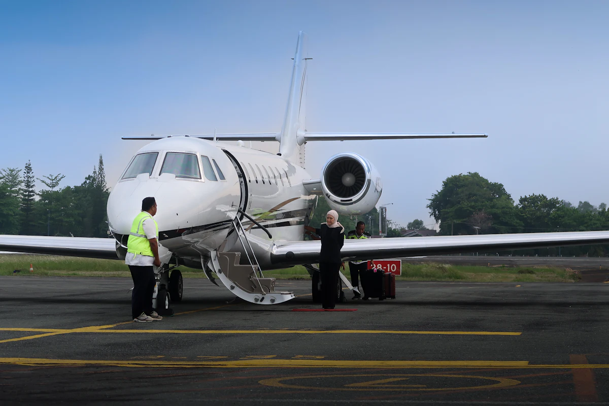 Crew standing beside a private jet on the tarmac
