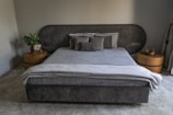 A modern bedroom shows a bed and furnishings.