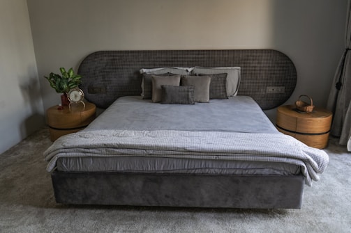 A modern bedroom shows a bed and furnishings.