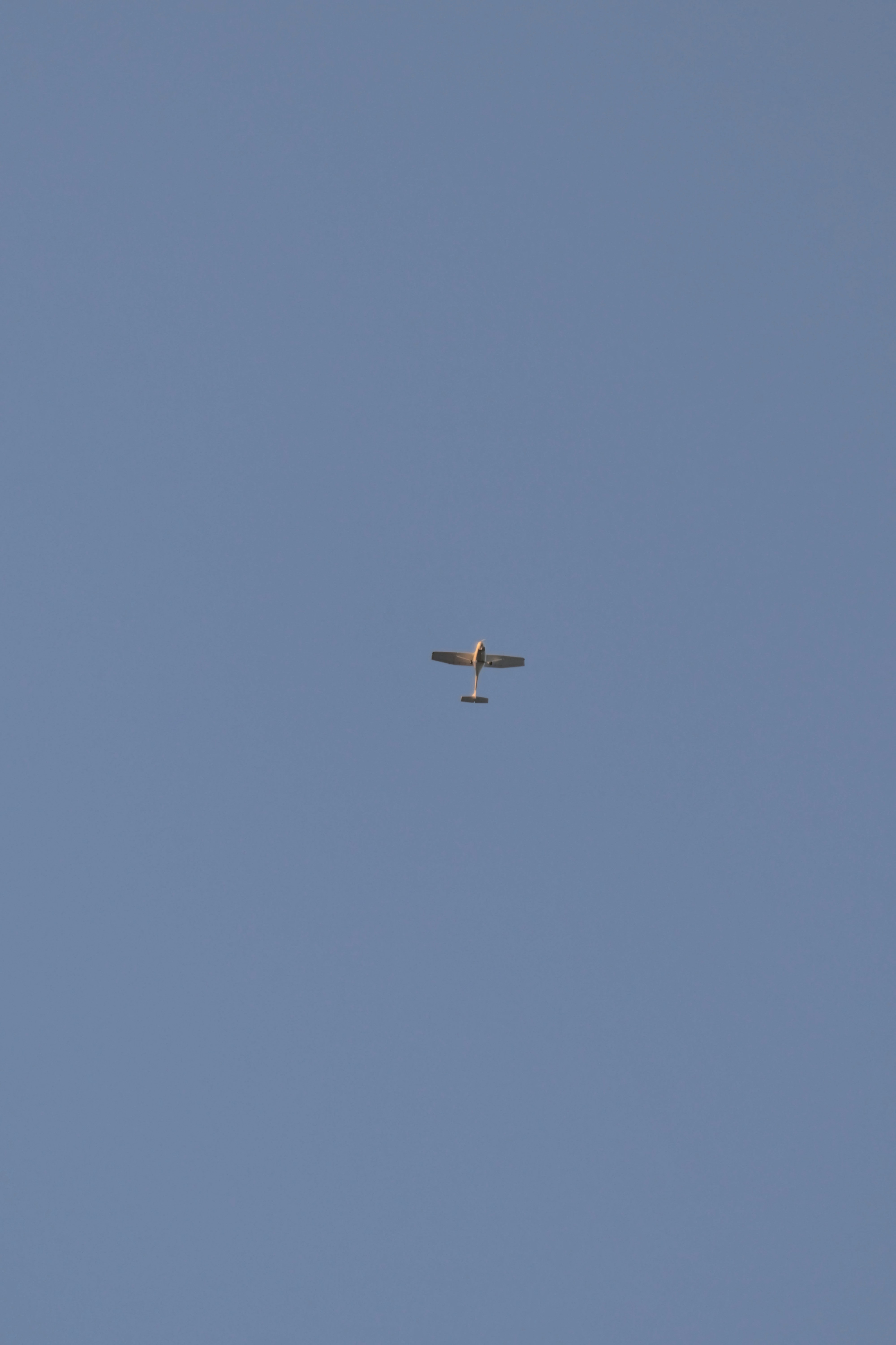 A small airplane flies in the clear sky.