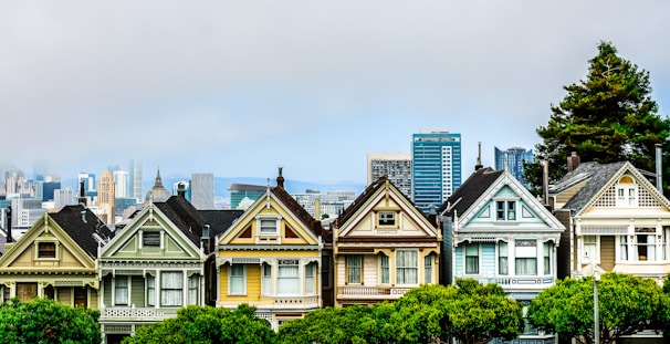 Painted ladies in san francisco with city skyline.