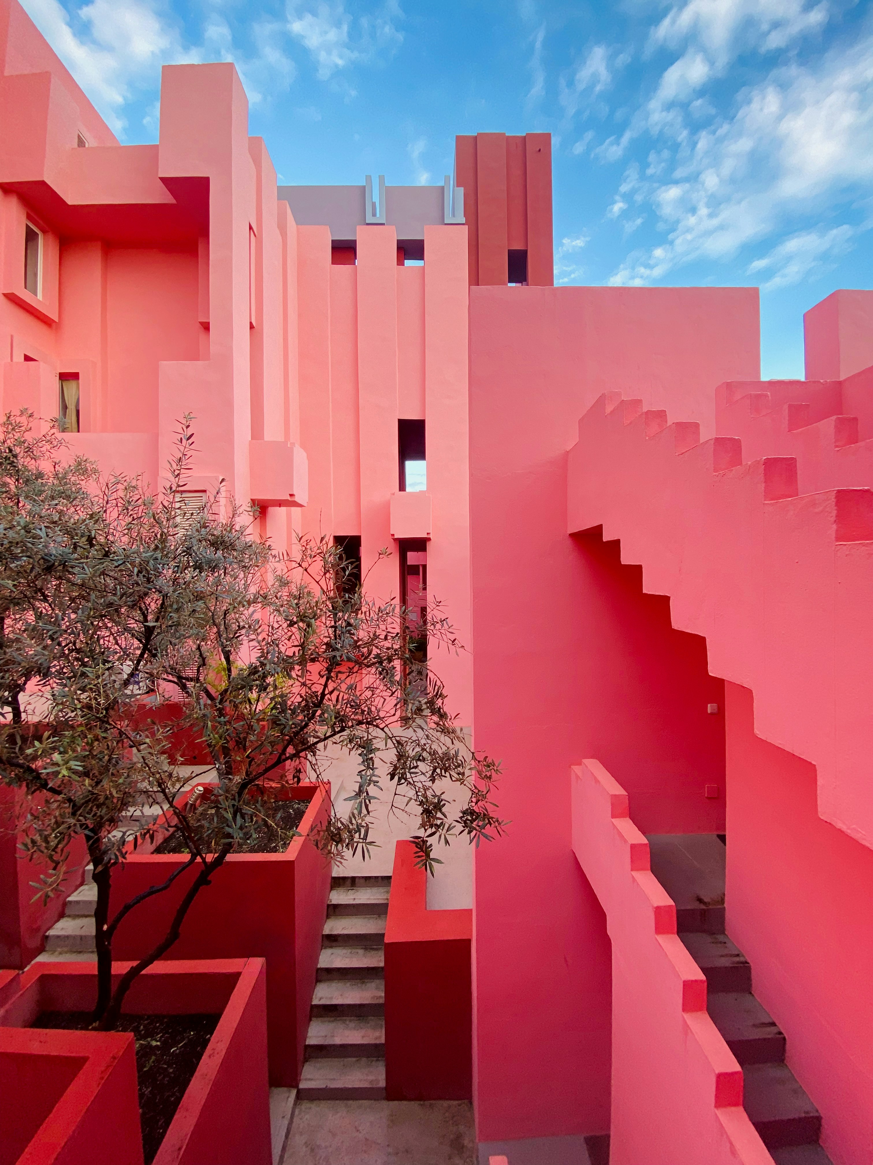 Pink geometric architecture against a blue sky.