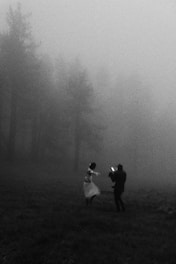 A photographer captures a dancing woman in a misty forest.
