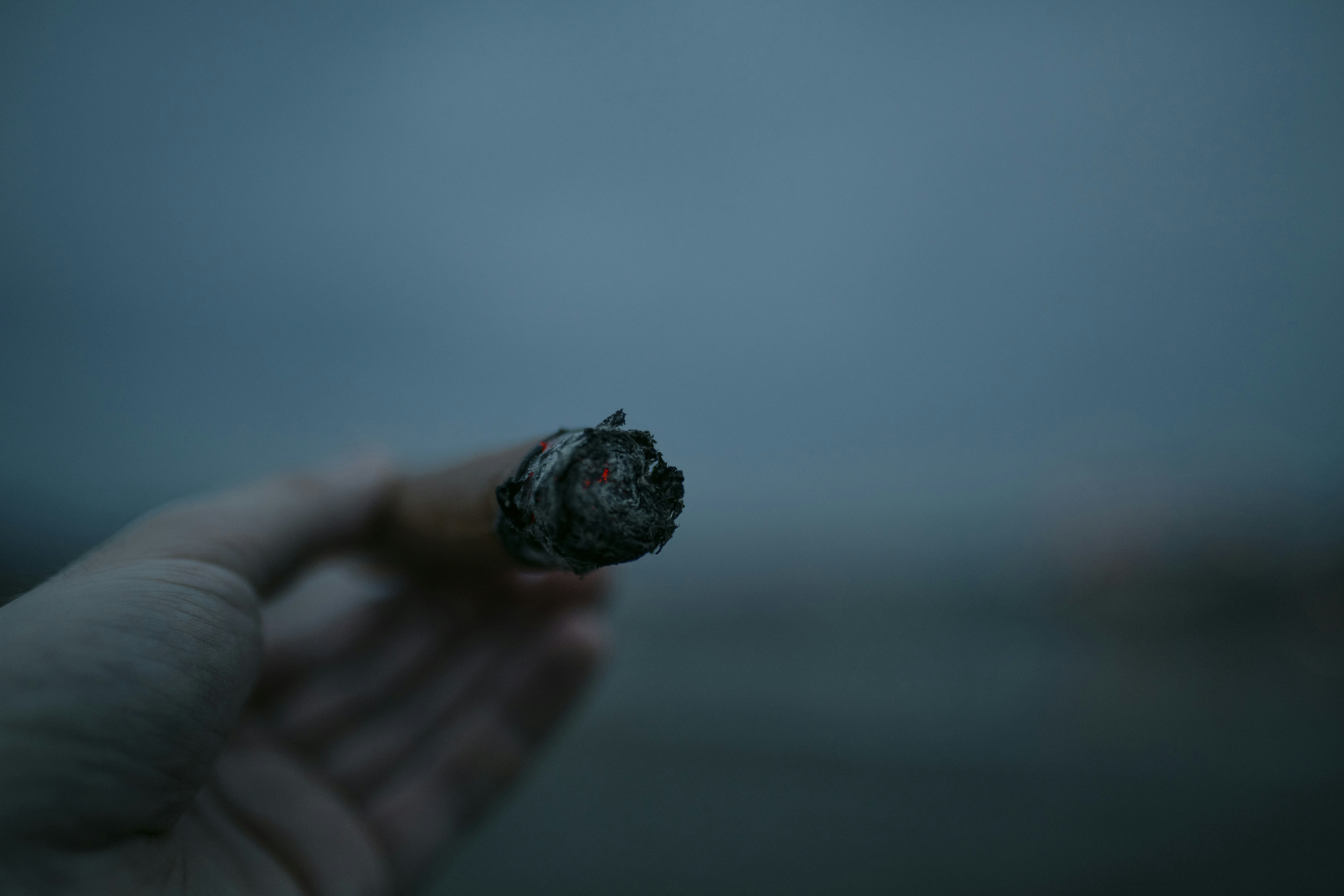 Yanan bir puro tutan el