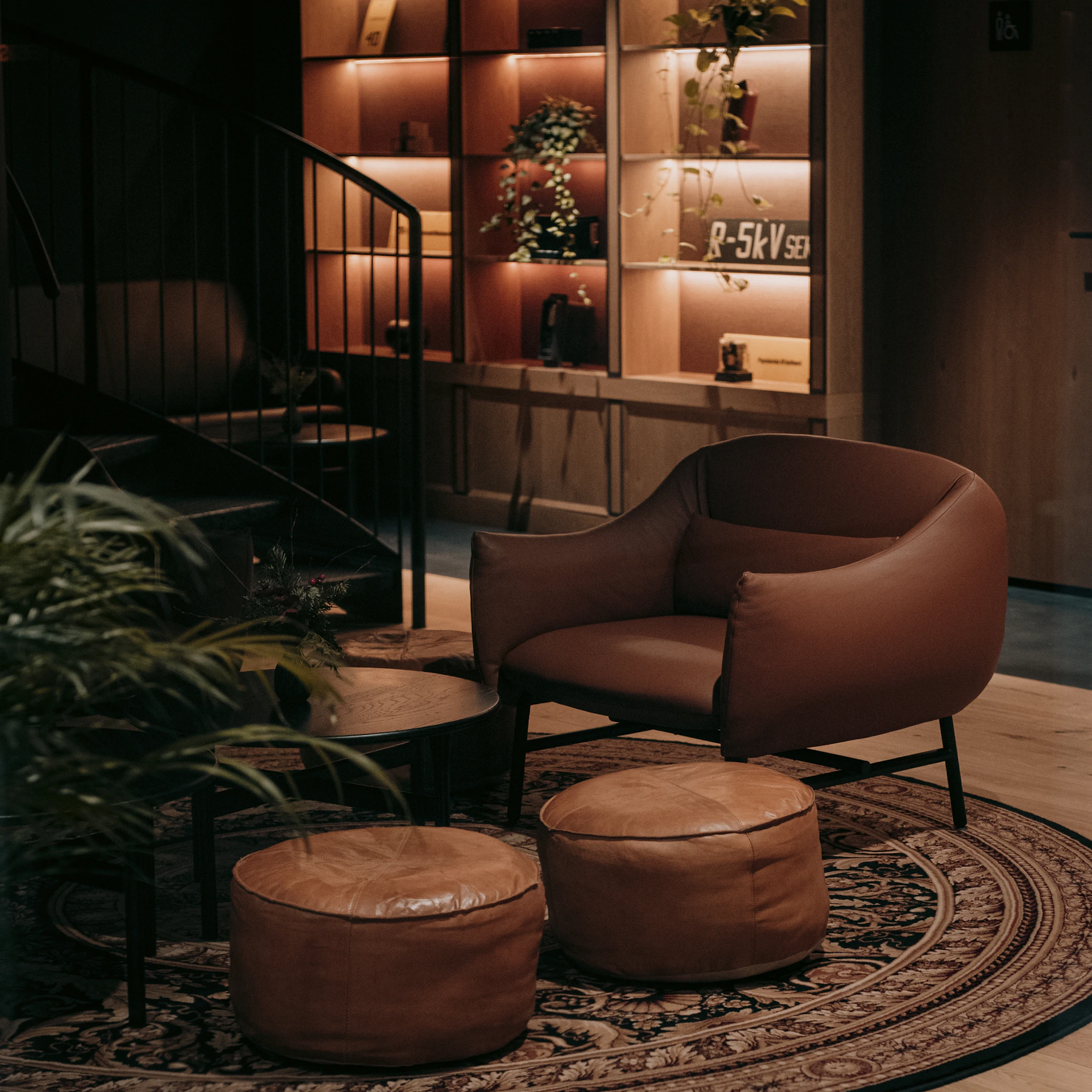 Cozy armchair and ottoman in a dimly lit room.