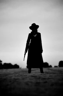 A western woman stands with a gun