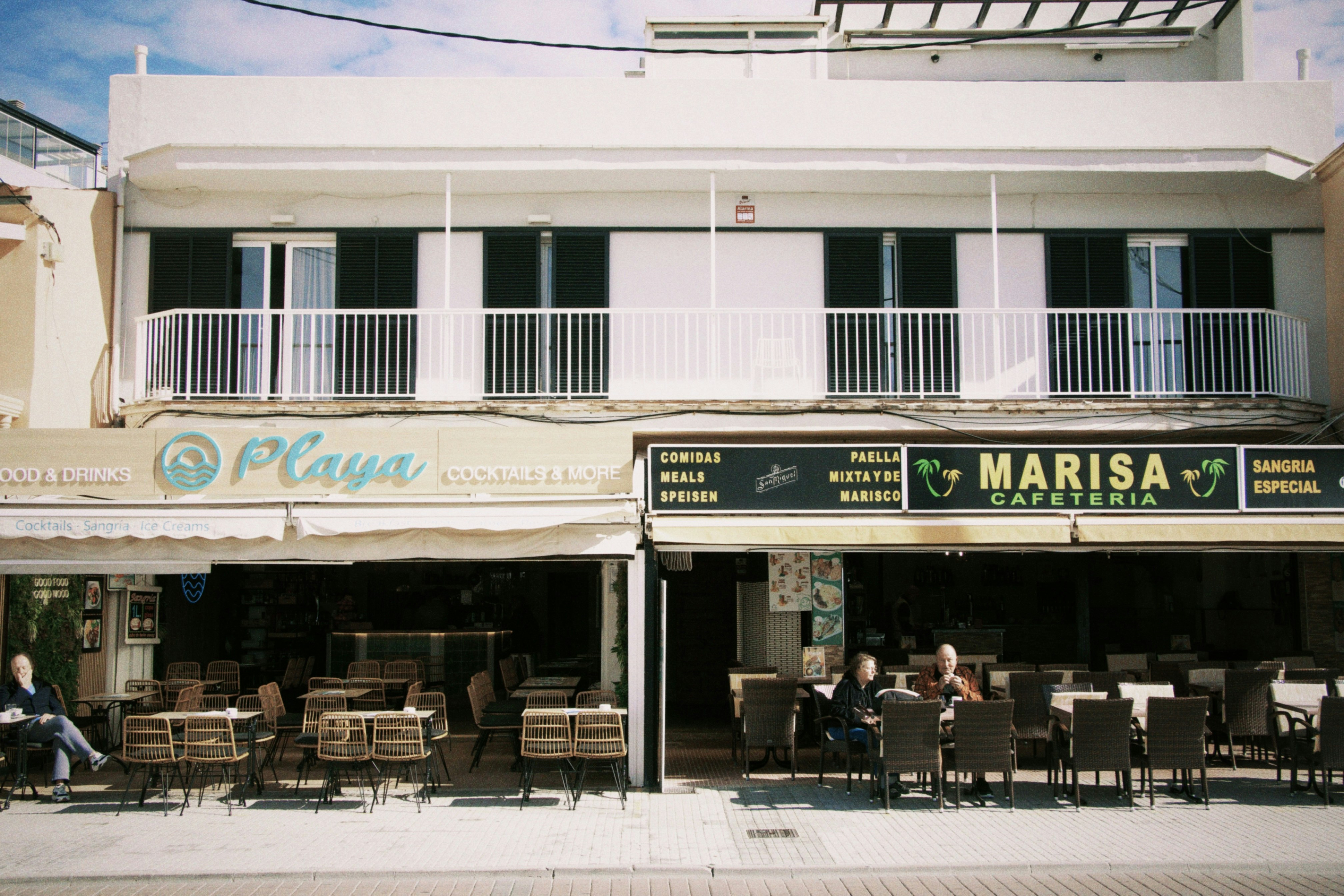 Shops and apartments are shown in a sunny location.