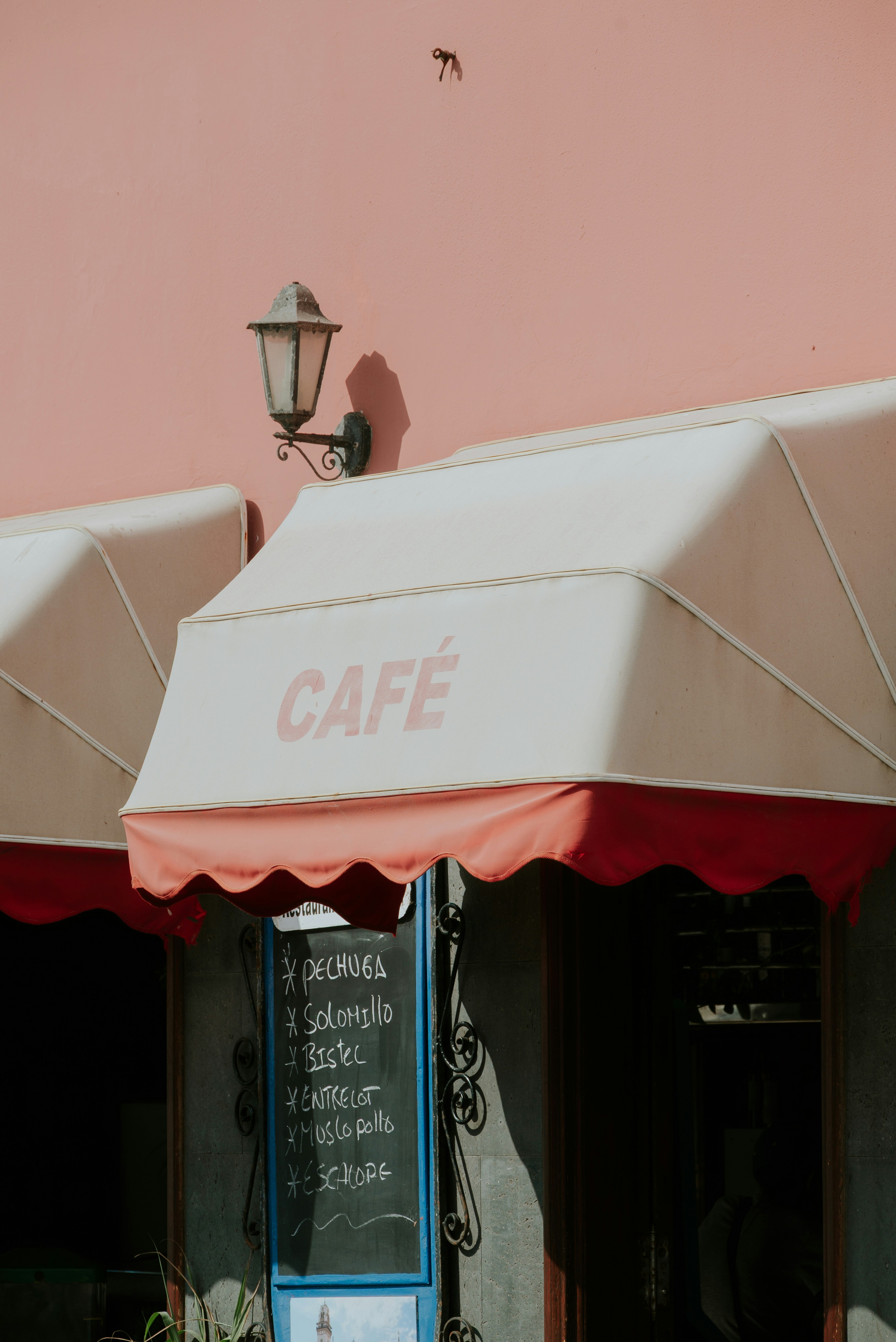 A charming cafe with red and white awnings.