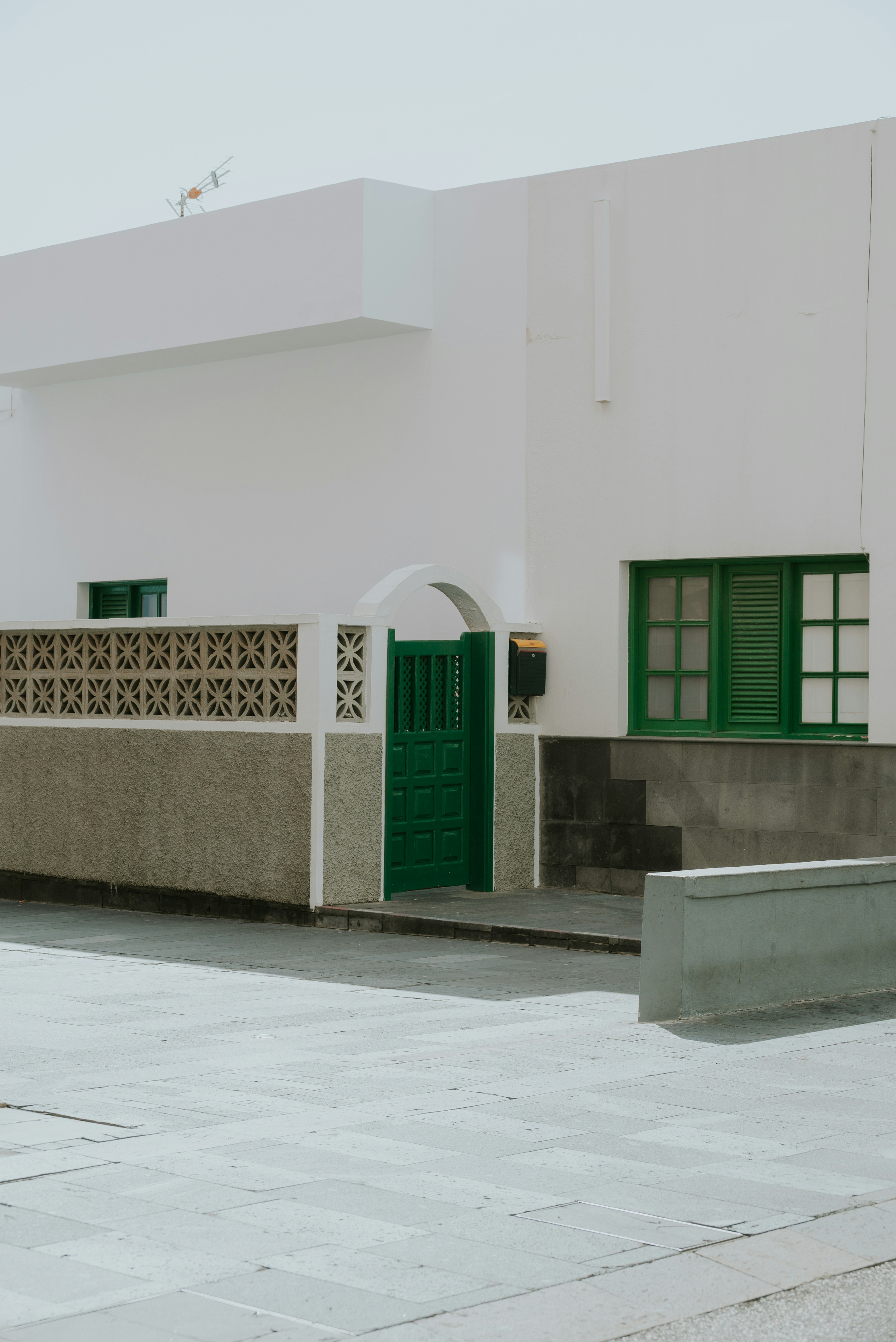 A white house with green doors and windows.
