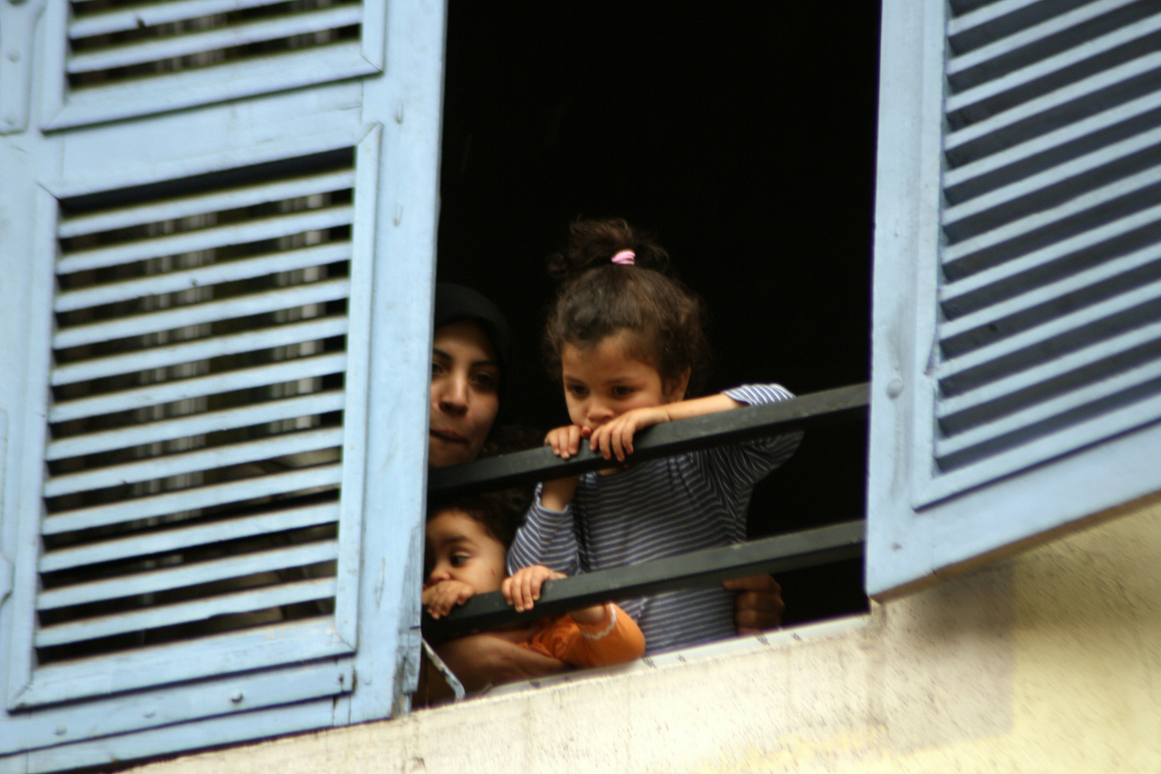 Three people look out of a window., Human Window