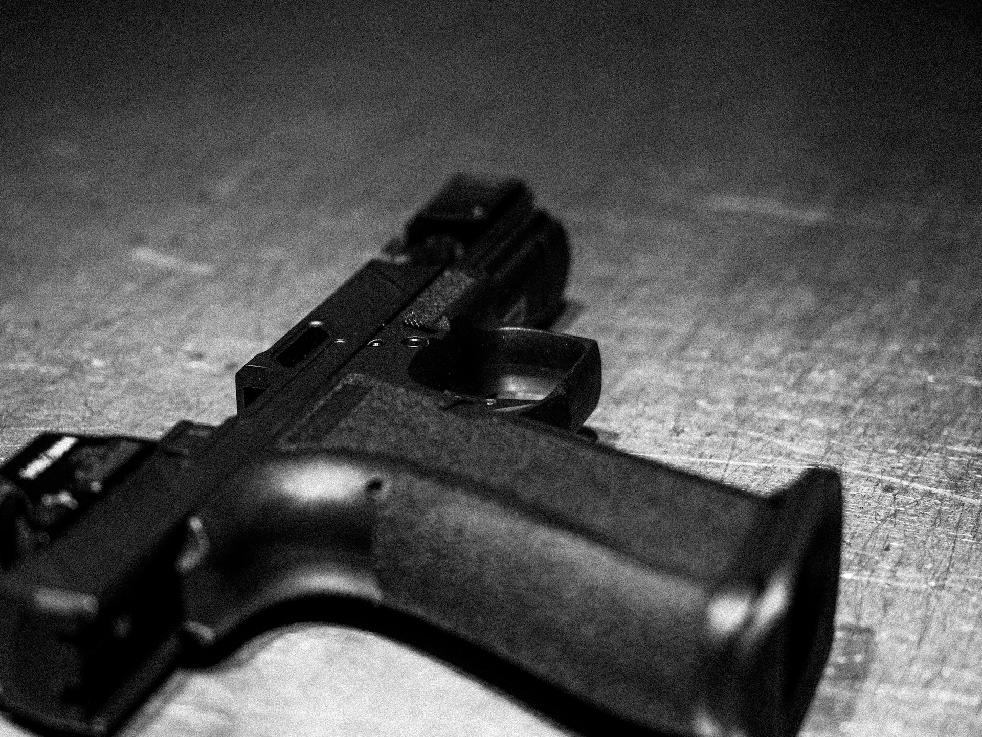 A handgun rests on a rough surface.