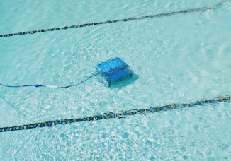A robotic pool cleaner is working underwater.