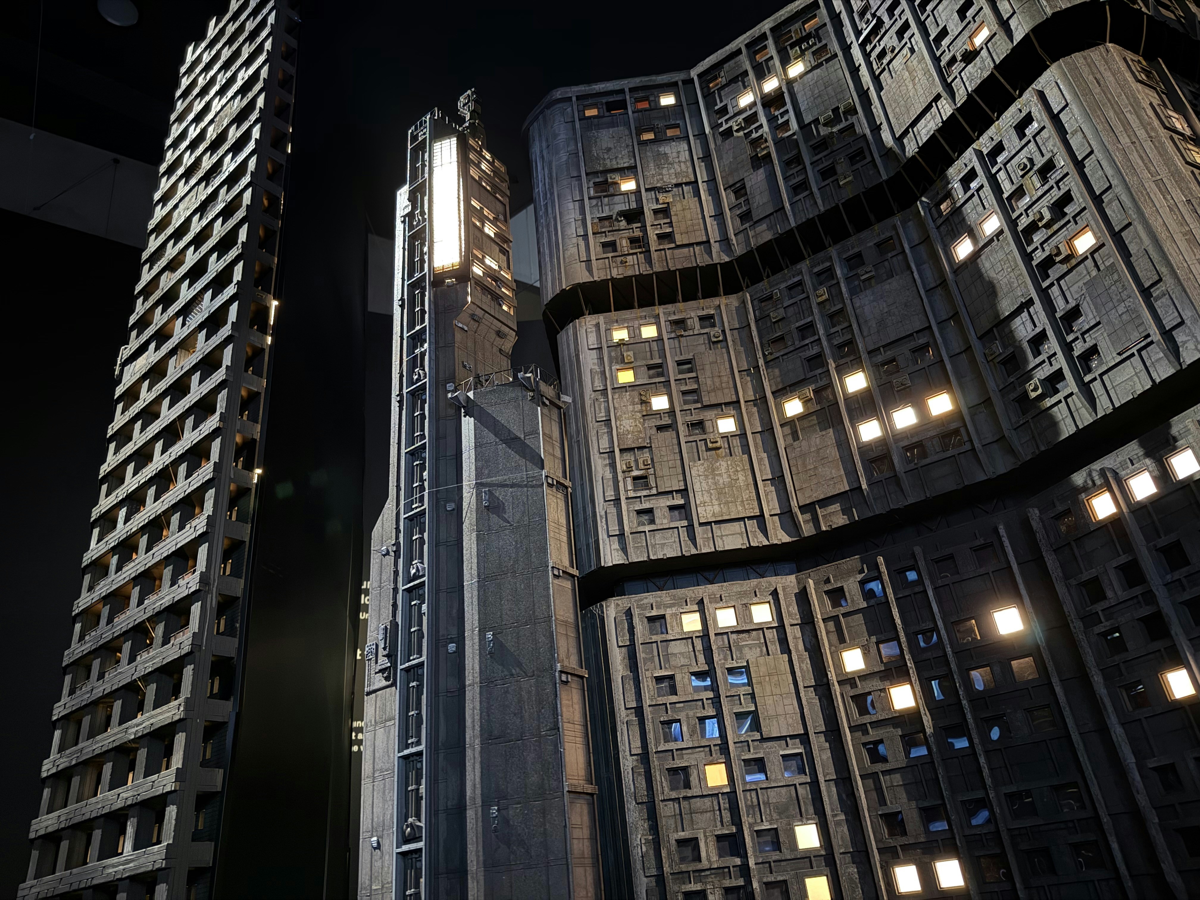 Buildings with glowing windows against a dark background.