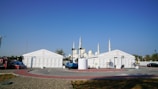 Temporary tents stand near a white mosque.