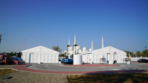 Temporary tents stand near a white mosque.