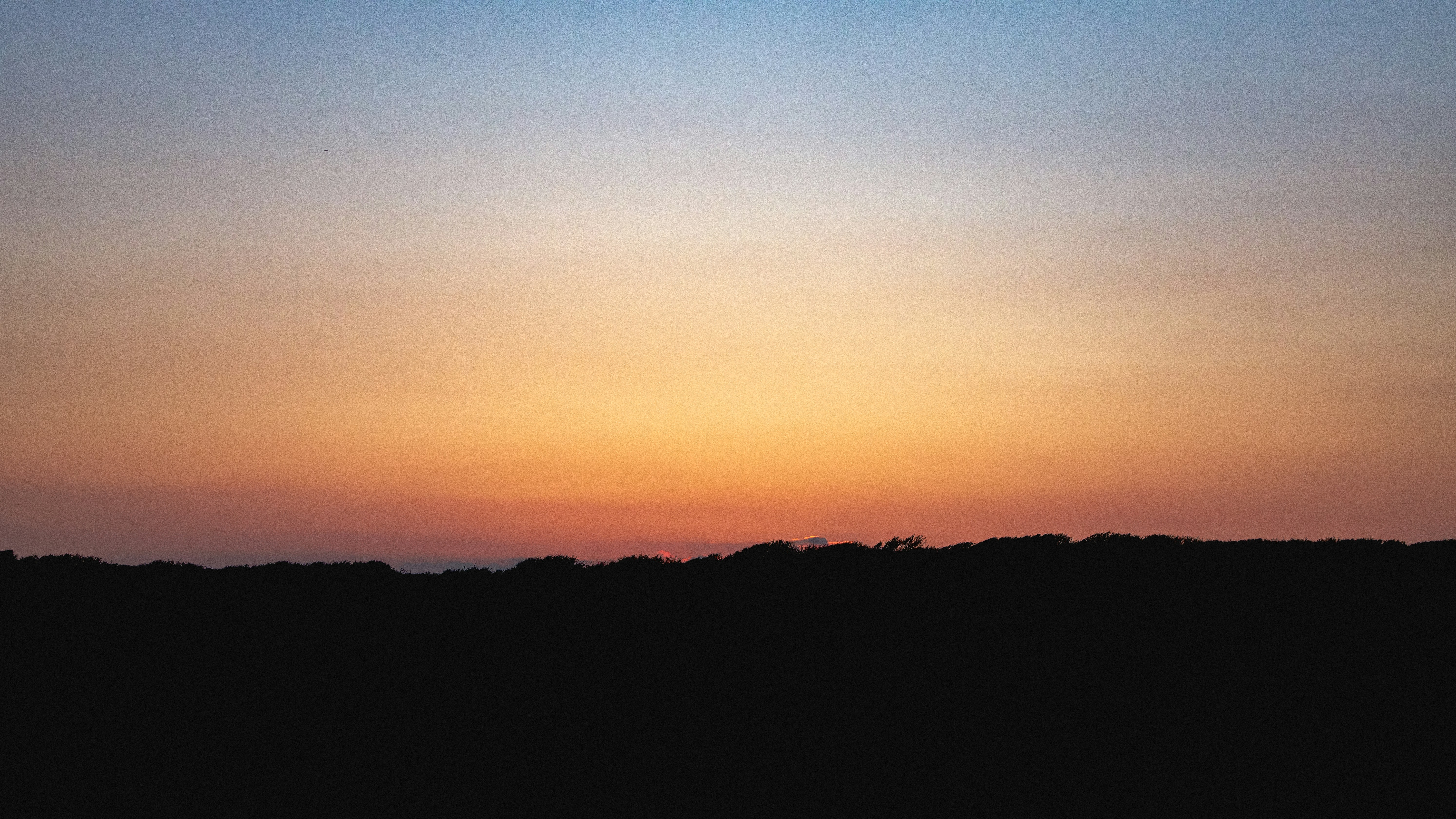 Sunset over a dark silhouette.