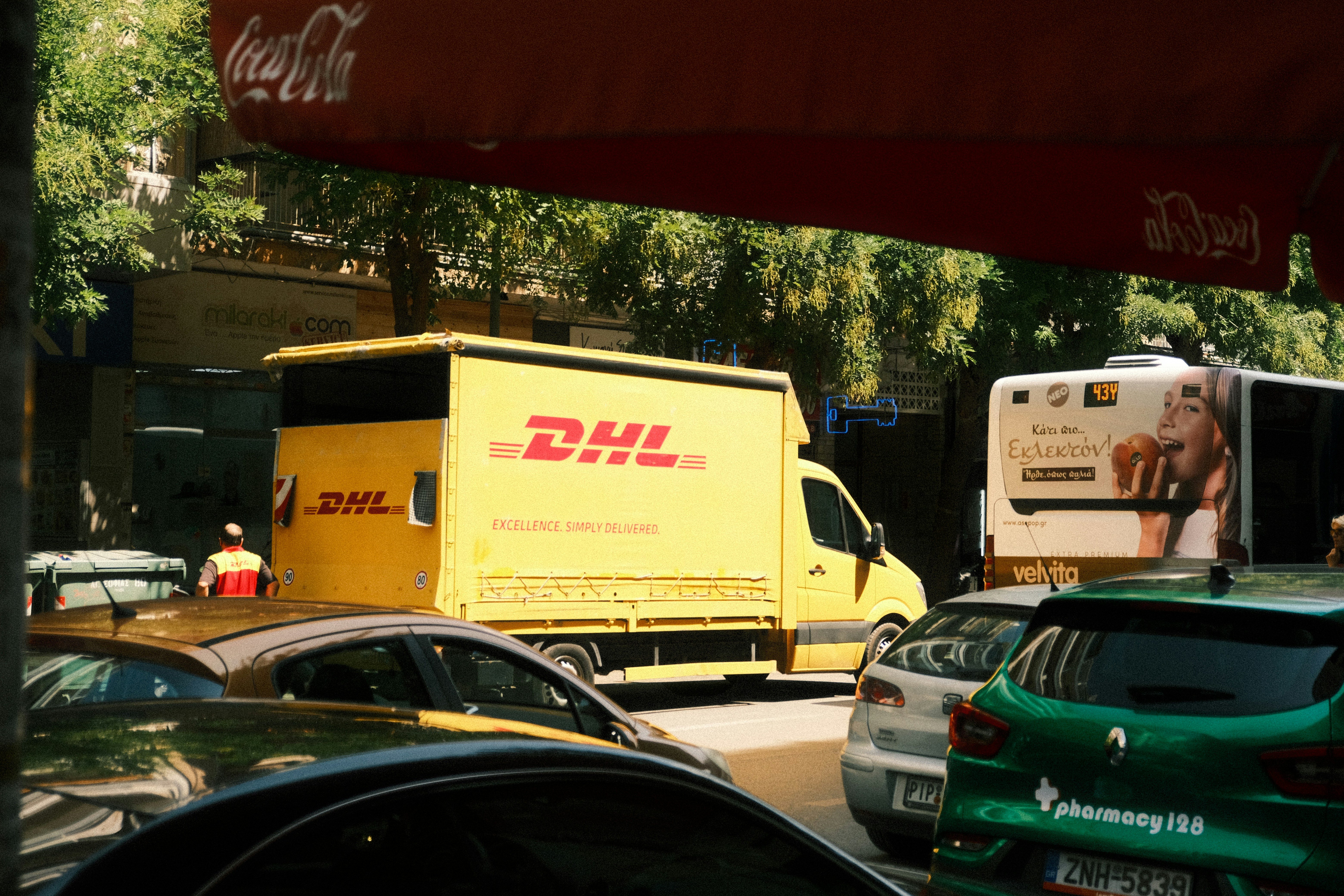 A dhl truck is stuck in traffic.