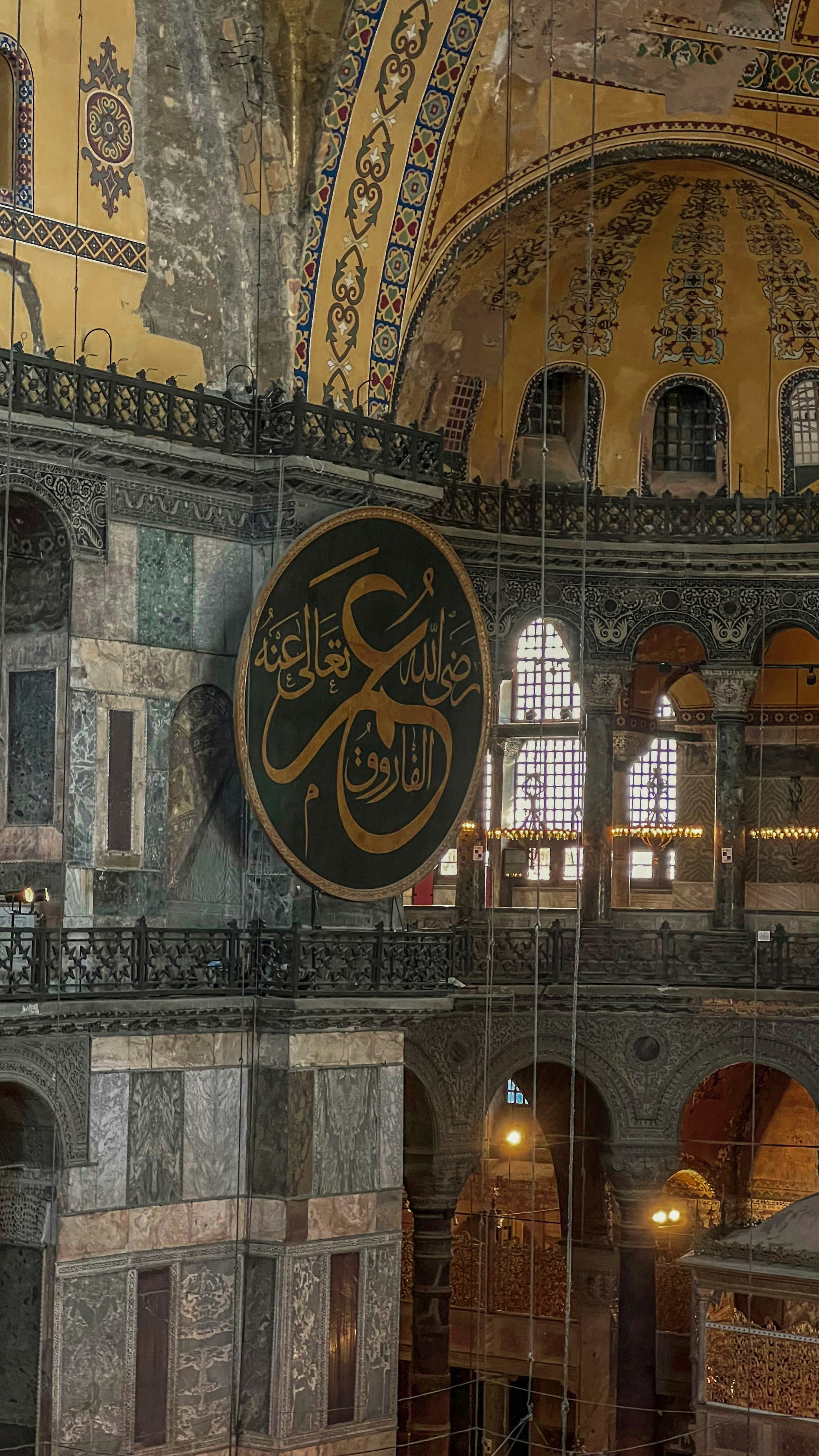 Intricate interior of a historical mosque with calligraphy.