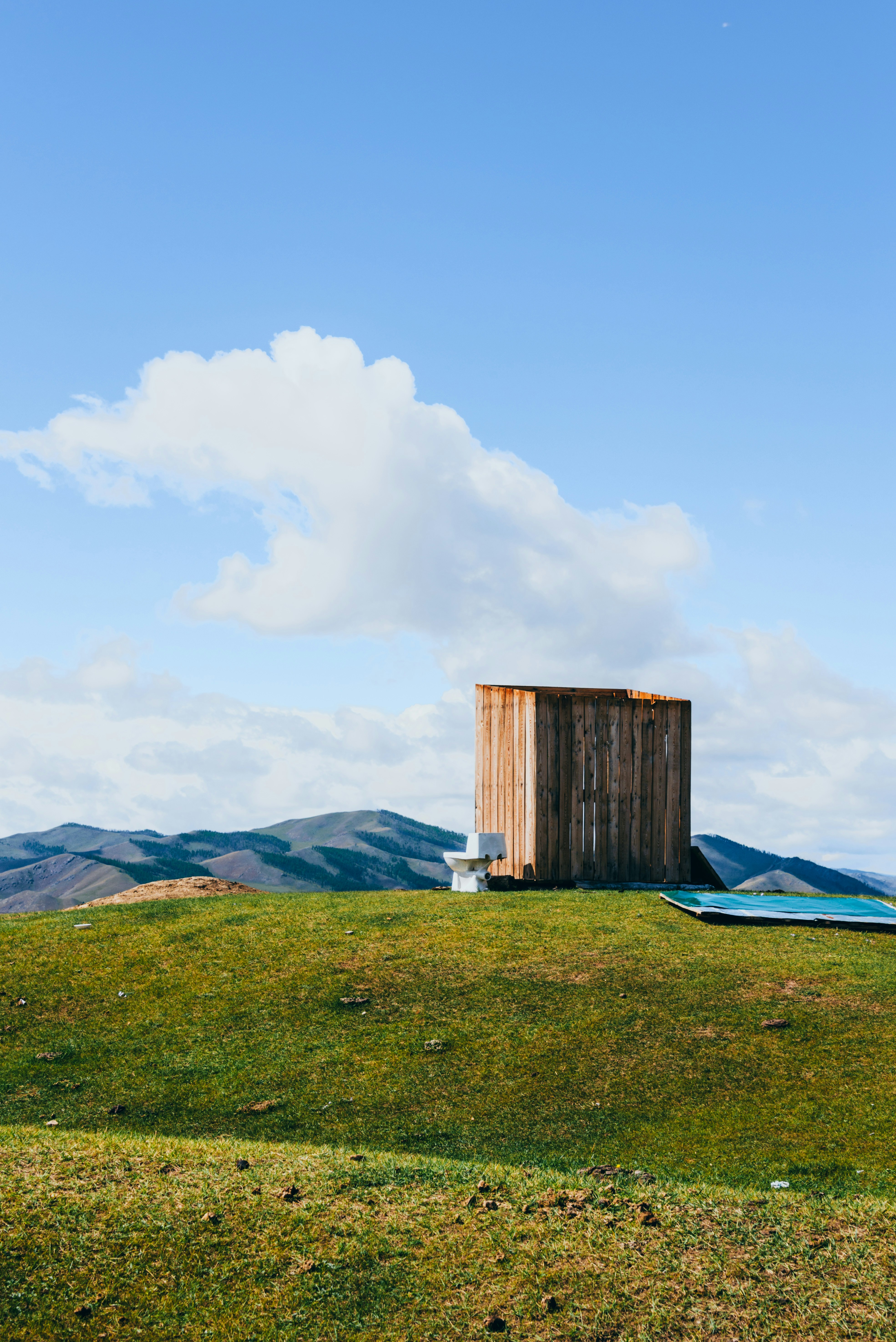 La estructura de madera se encuentra en la cima de una colina verde.