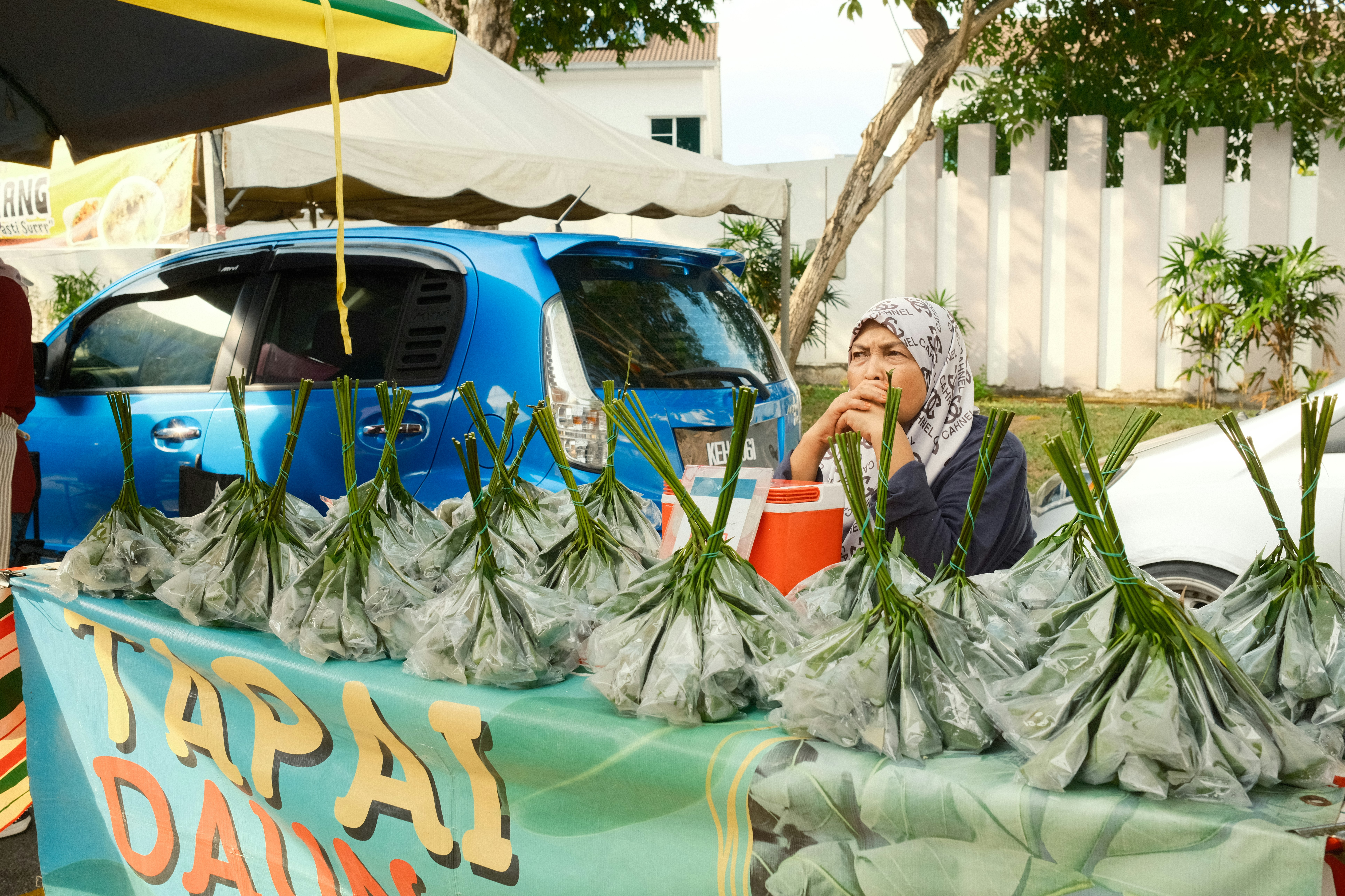 Wanita menjual makanan di pasar luar ruangan.