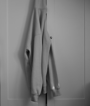 A hoodie is hanging on a closed door.