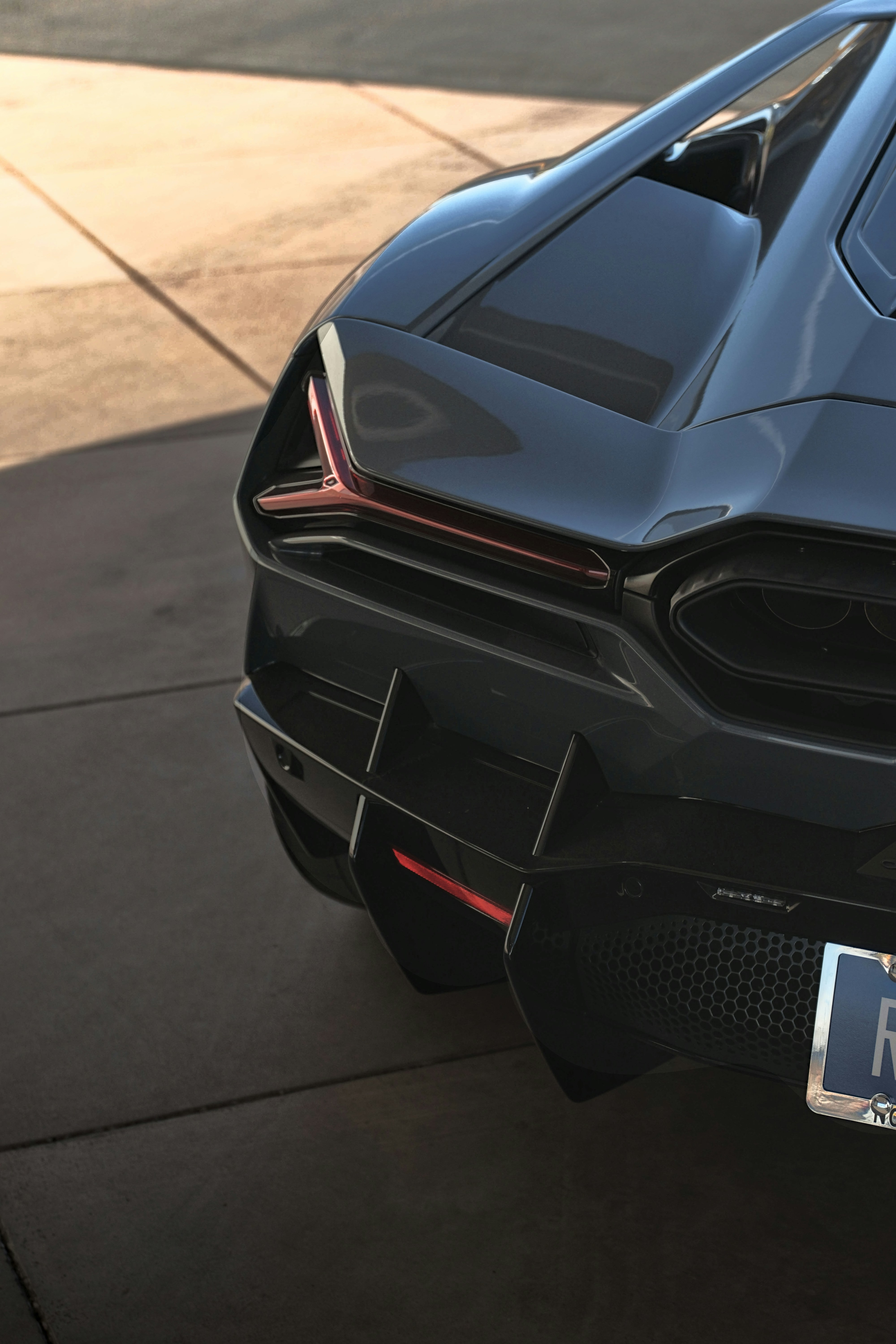 A sleek, grey sports car's rear.
