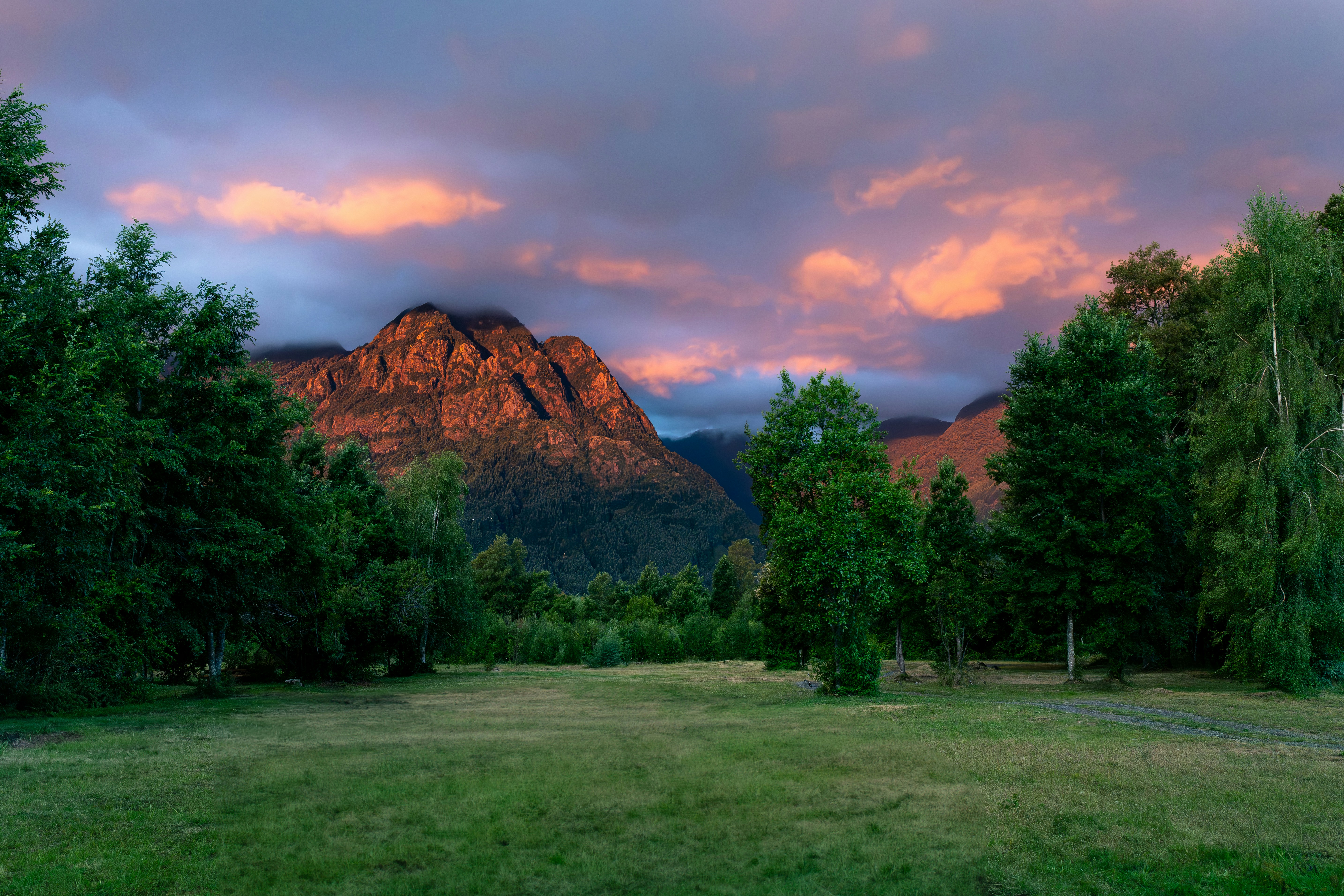 Sunset illuminates mountains and trees.
