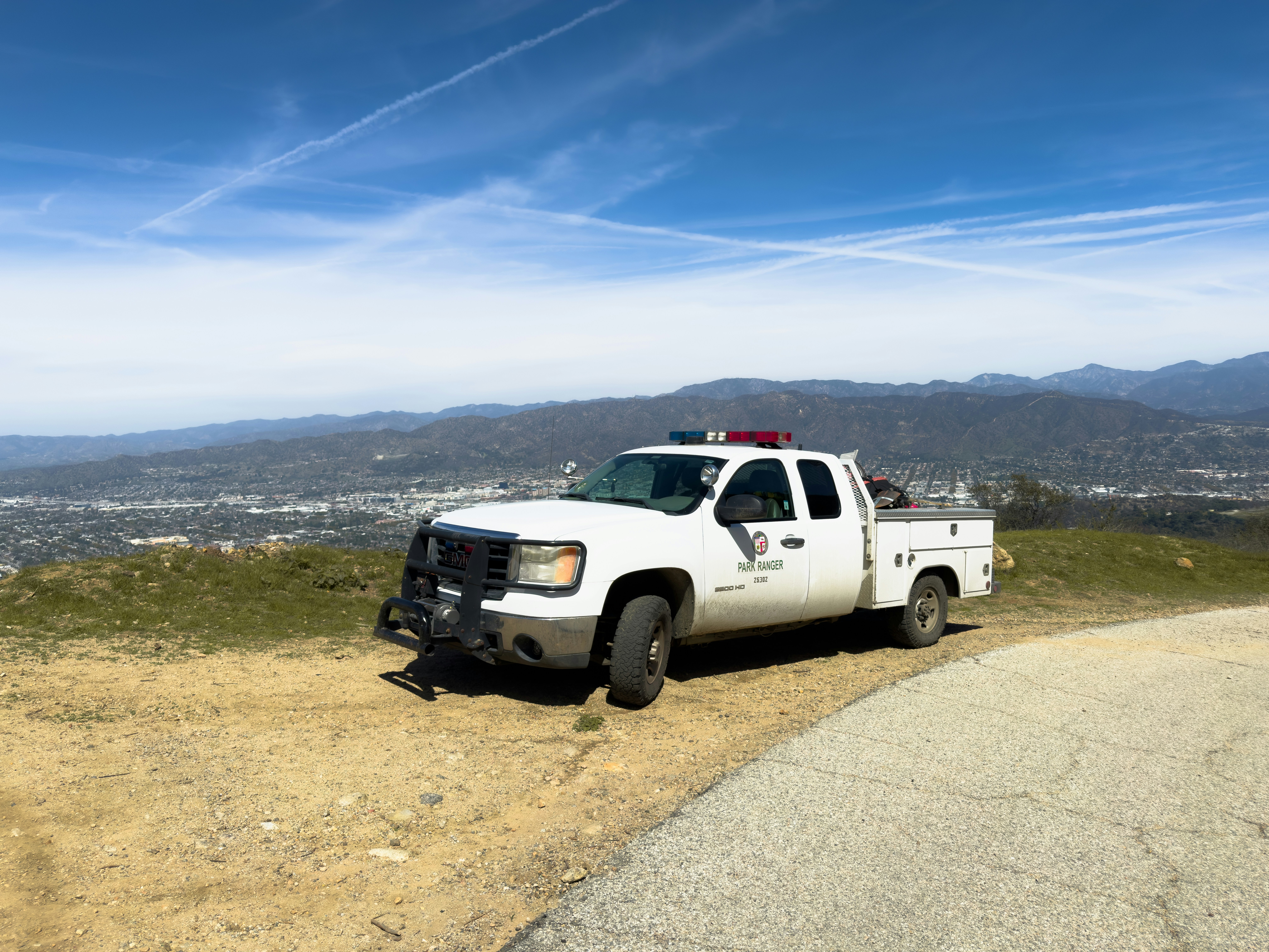 A white truck overlooks a scenic vista.