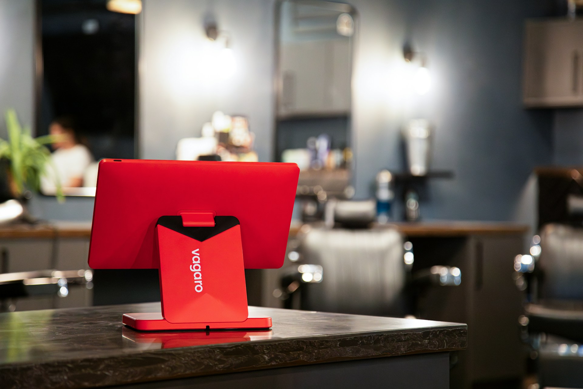 A red pos system sits on a salon counter.