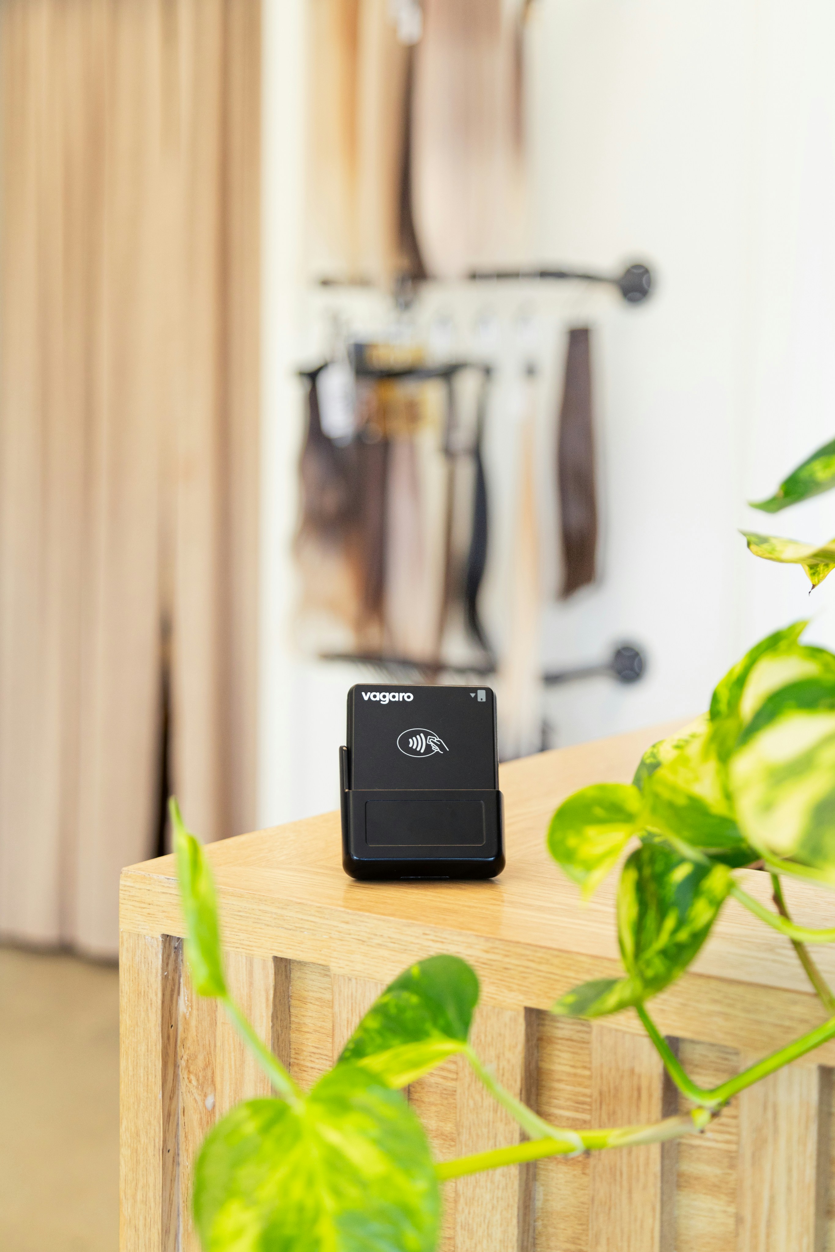 A credit card reader sits on a wooden counter.
