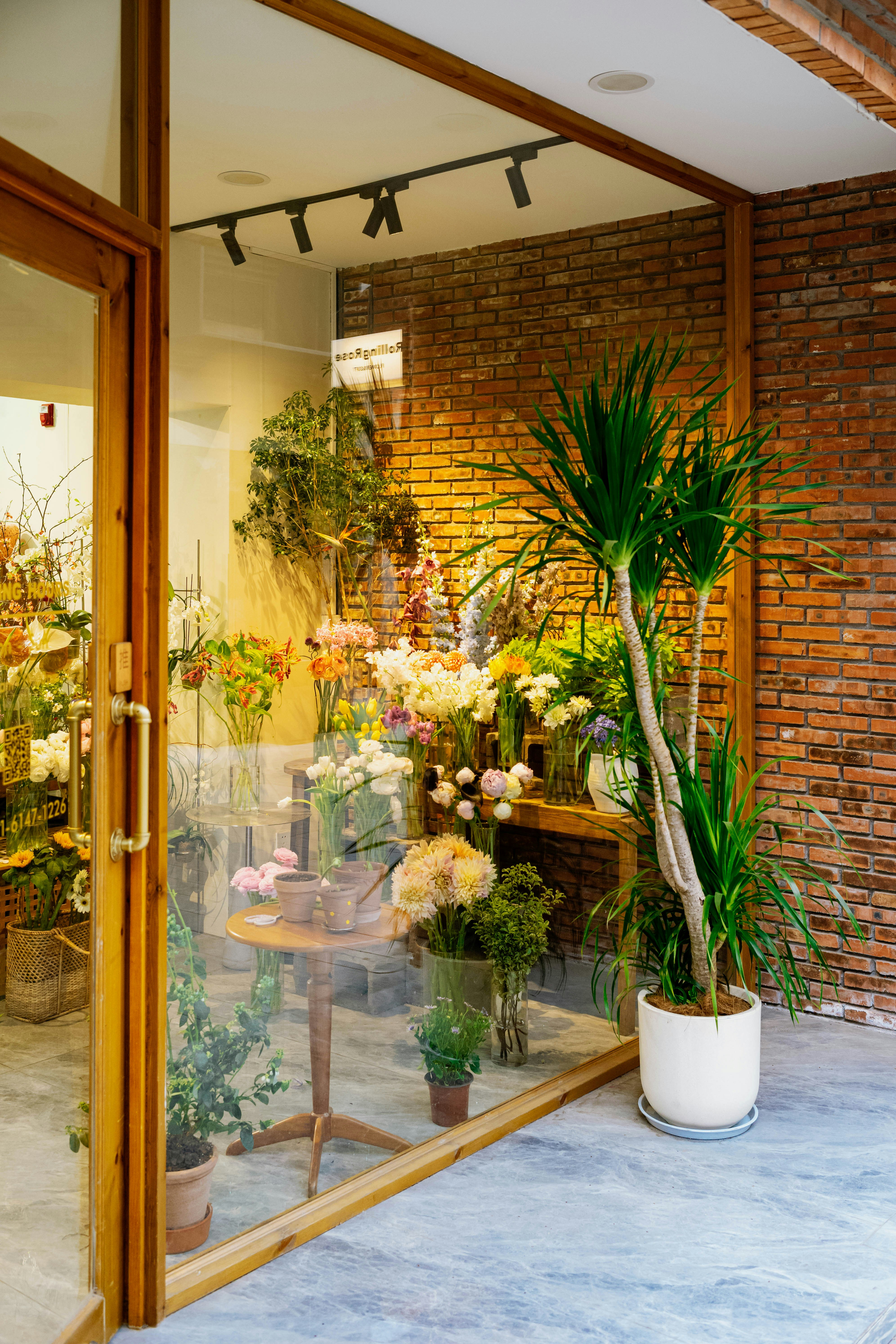 A flower shop with a display of flowers in the window photo – Free Woman  Image on Unsplash, image size:3000x4500
