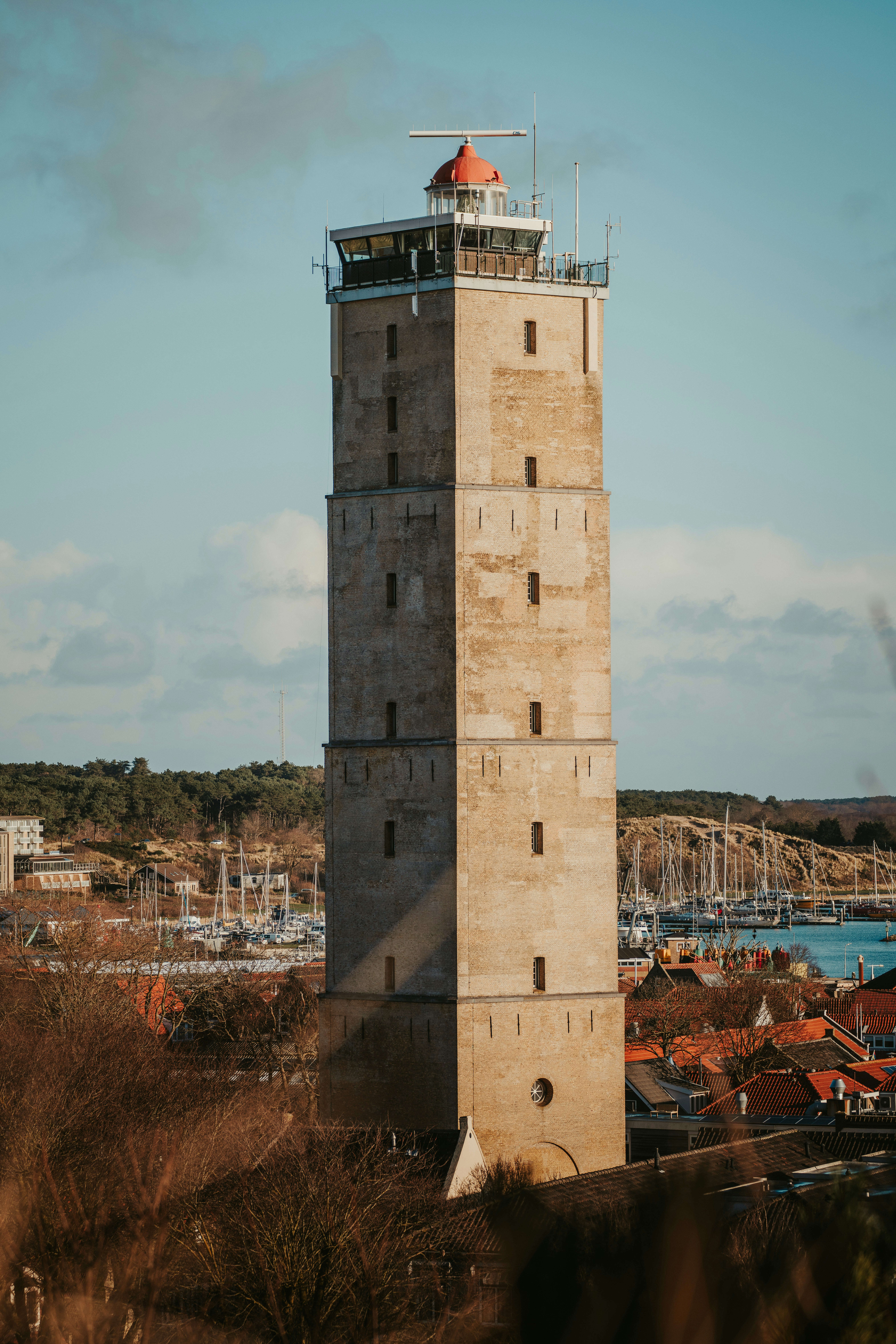 A tall lighthouse stands against a blue sky.