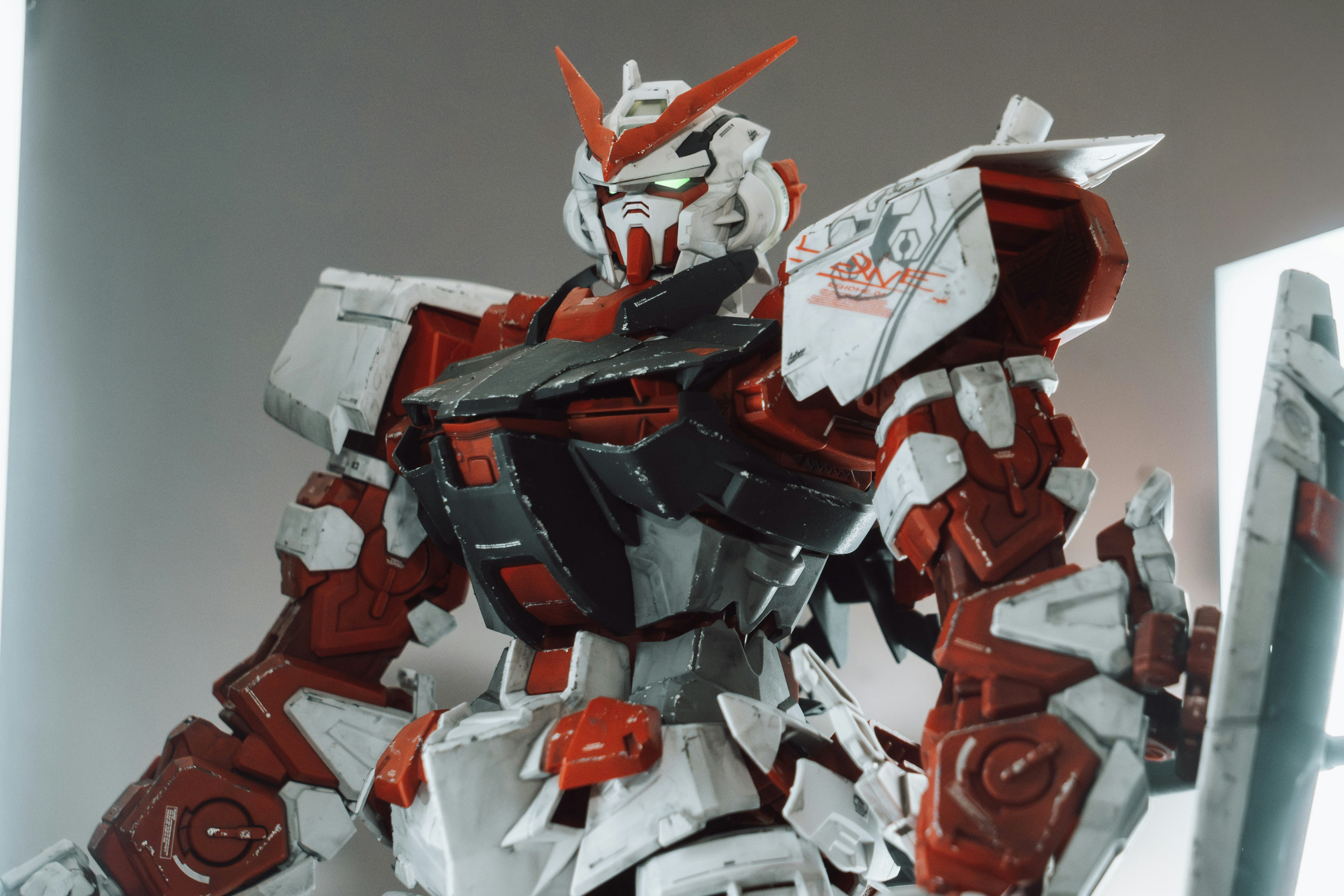 A red and white gundam robot stands proudly.