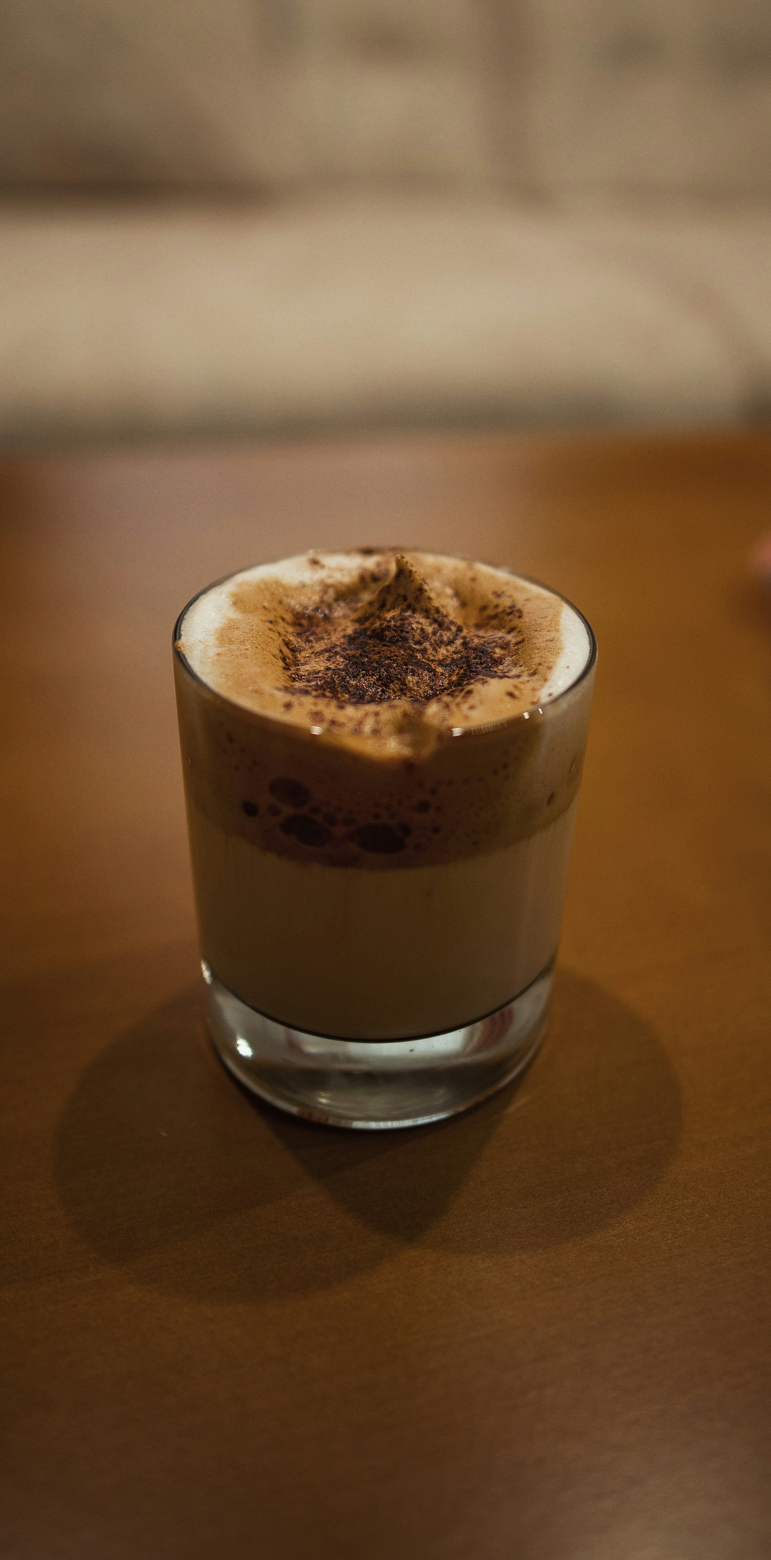 ダルゴナコーヒーはテーブルの上のグラスに置かれています。