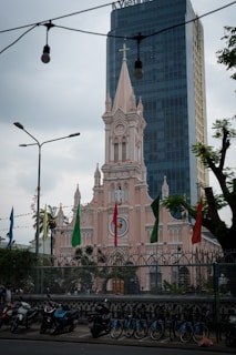 A pink church contrasts with a modern building.
