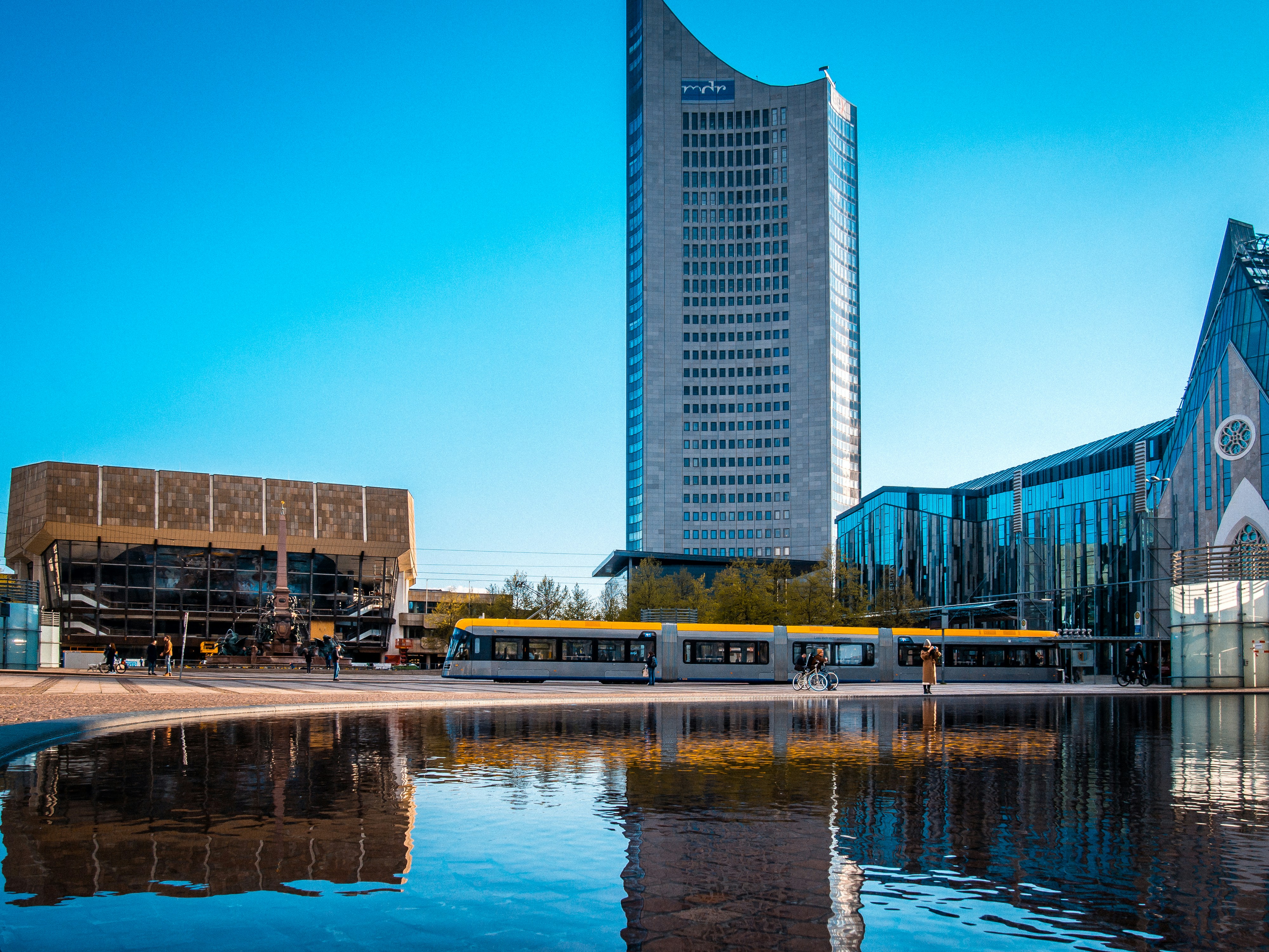 A modern cityscape with a tall building and water.